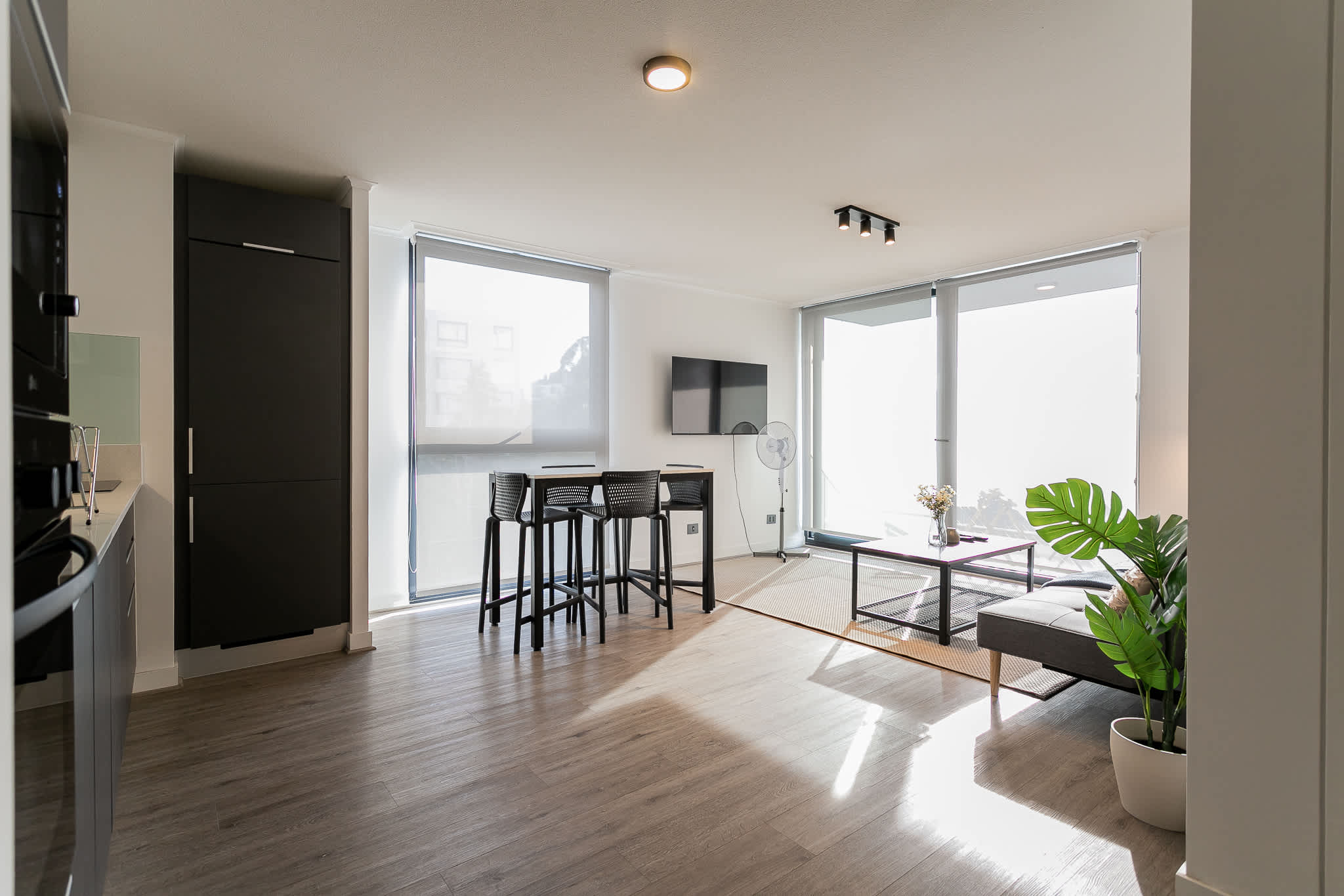 Bright and modern living space with floor-to-ceiling windows, perfect for relaxing or entertaining.