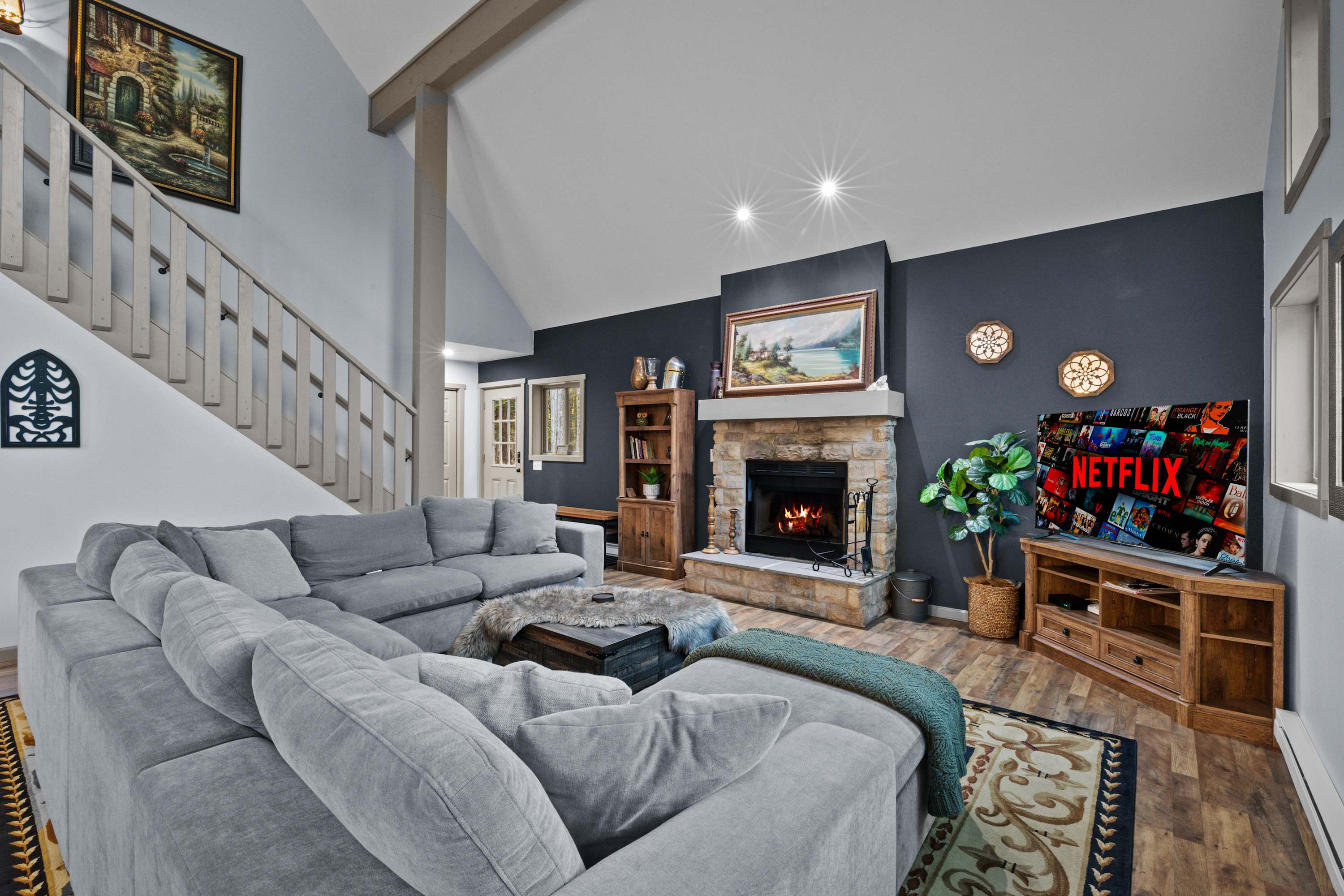 A spacious living room with a comfy couch, wood-burning fireplace, and entertainment at your finger tips.