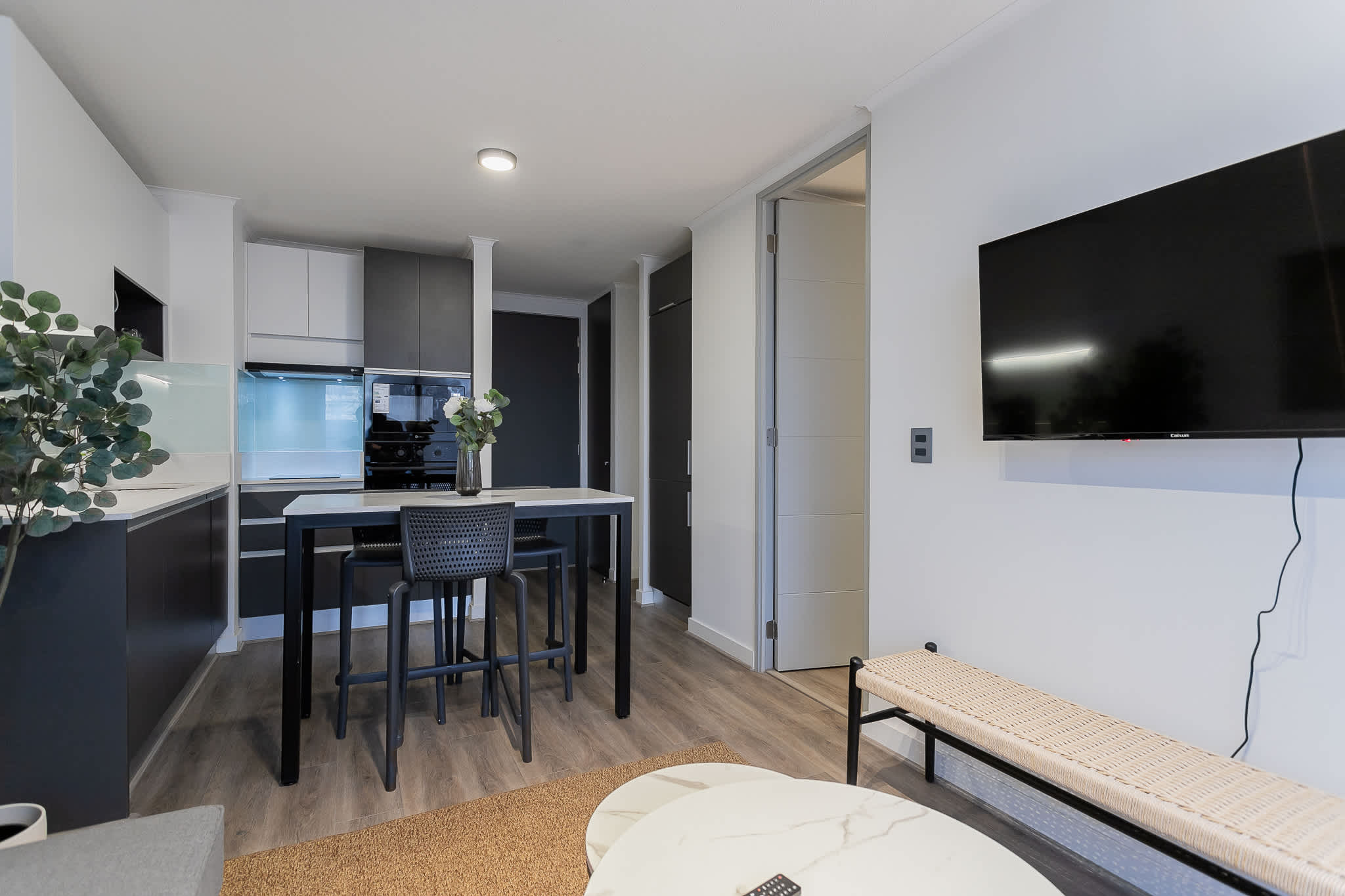 Chic and modern kitchen with stylish seating and a wall-mounted TV, perfect for relaxing after a day exploring the city.
