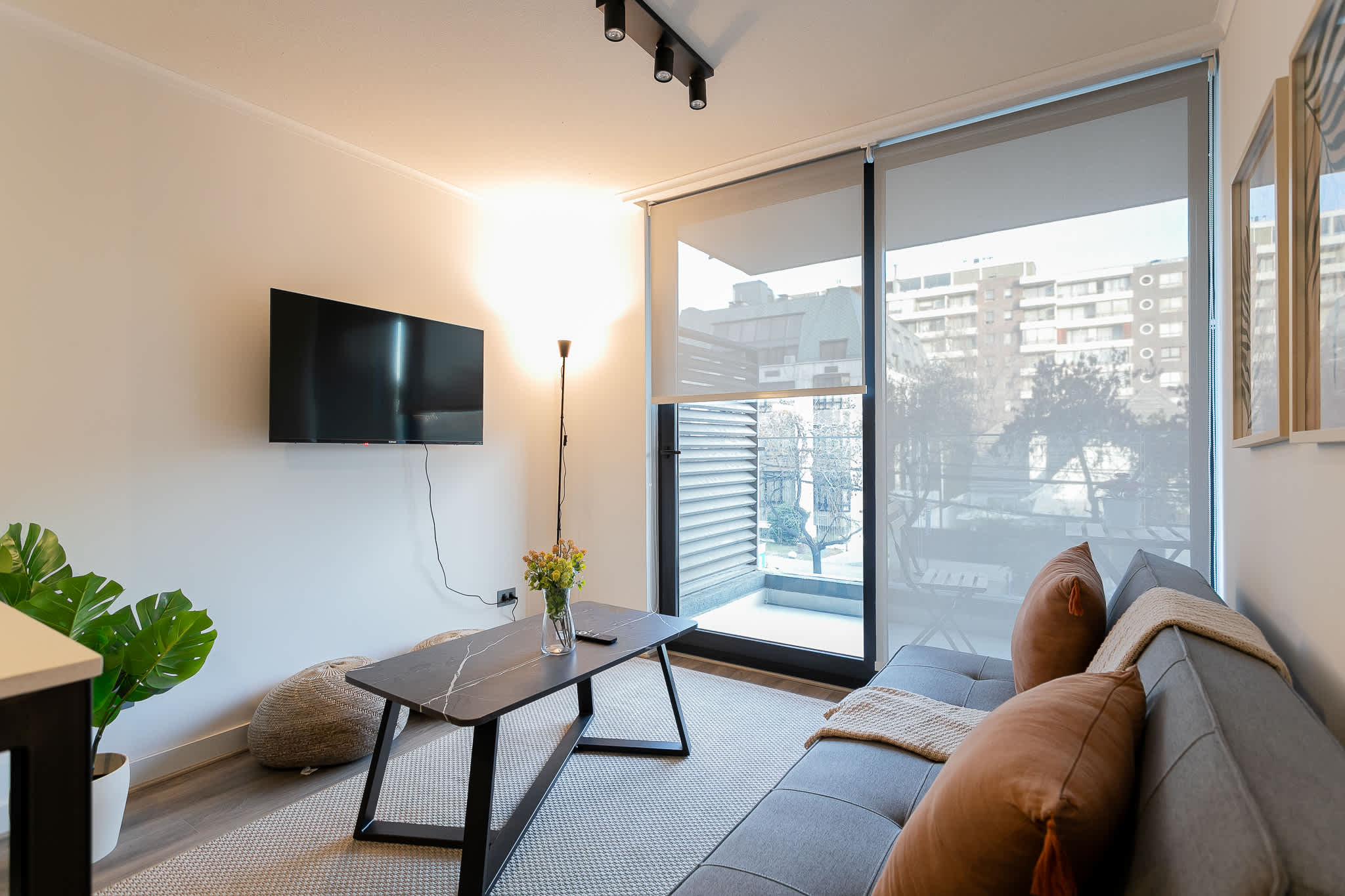 Relax in this stylish living room with a cozy sofa, modern decor, and a view of the cityscape through large windows.