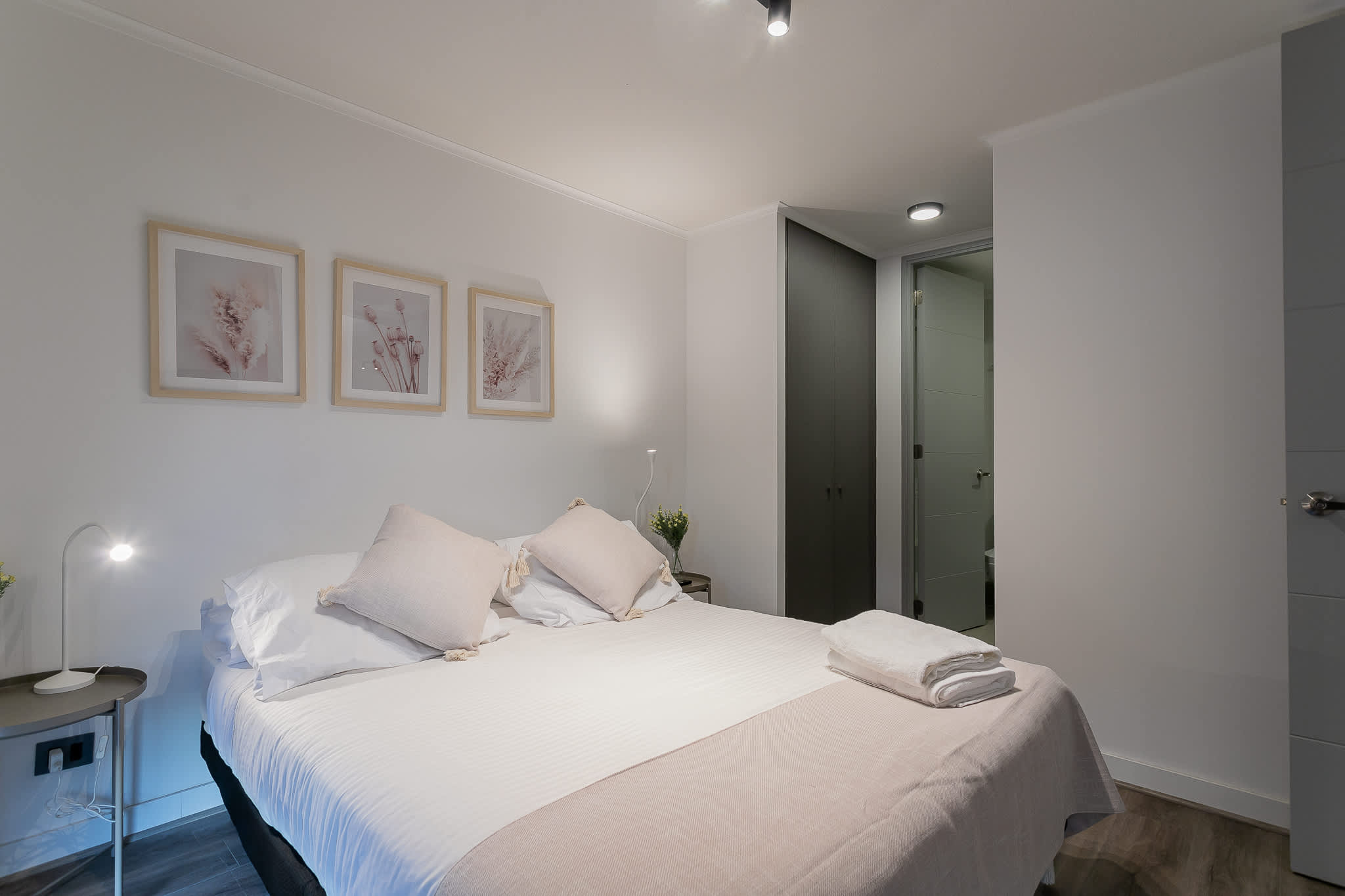 Relax in this serene bedroom with soft lighting and elegant decor, perfect for a restful night's sleep.