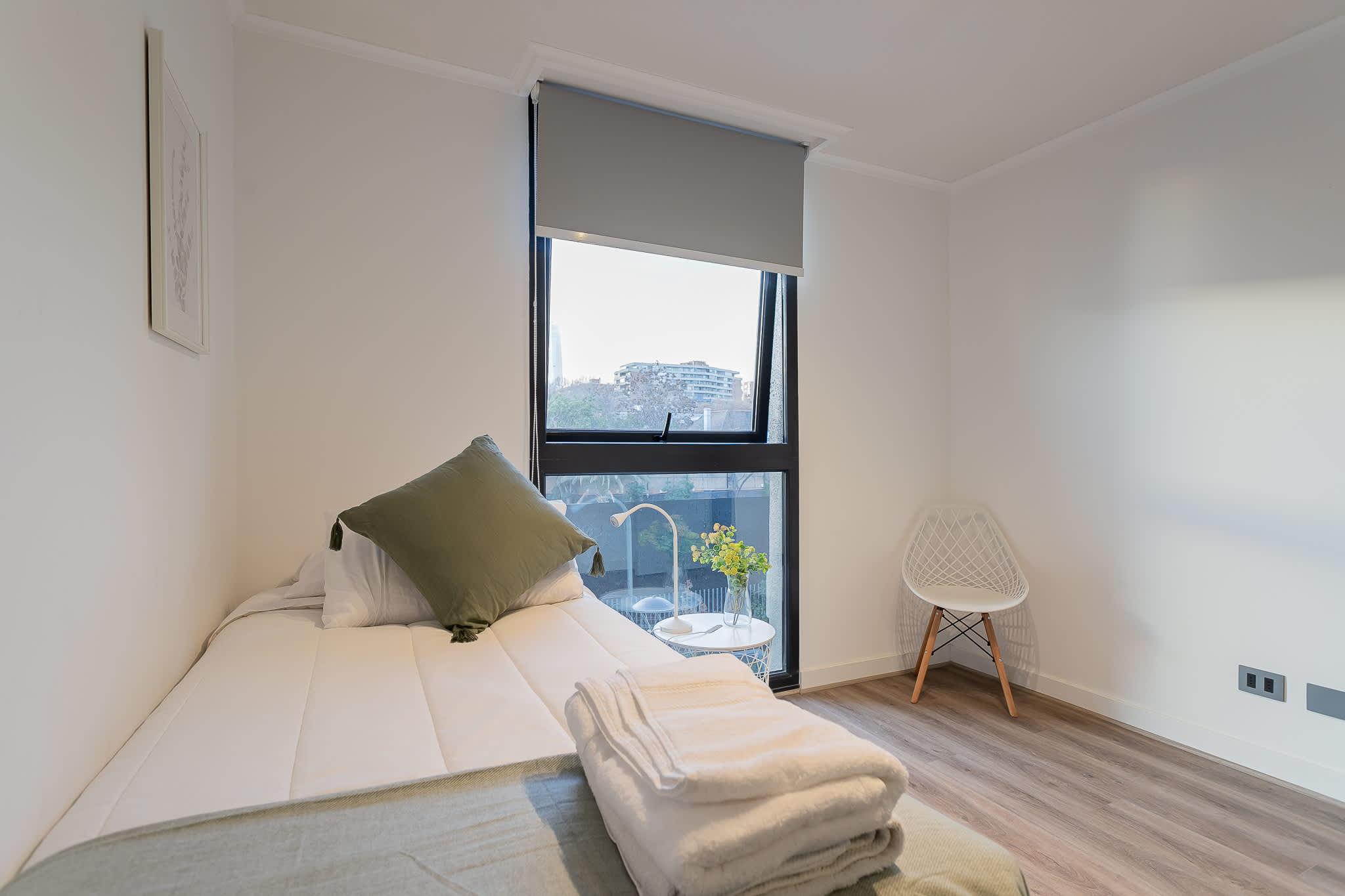 Cozy bedroom with a serene view, perfect for a restful stay. Enjoy natural light and minimalist comfort.