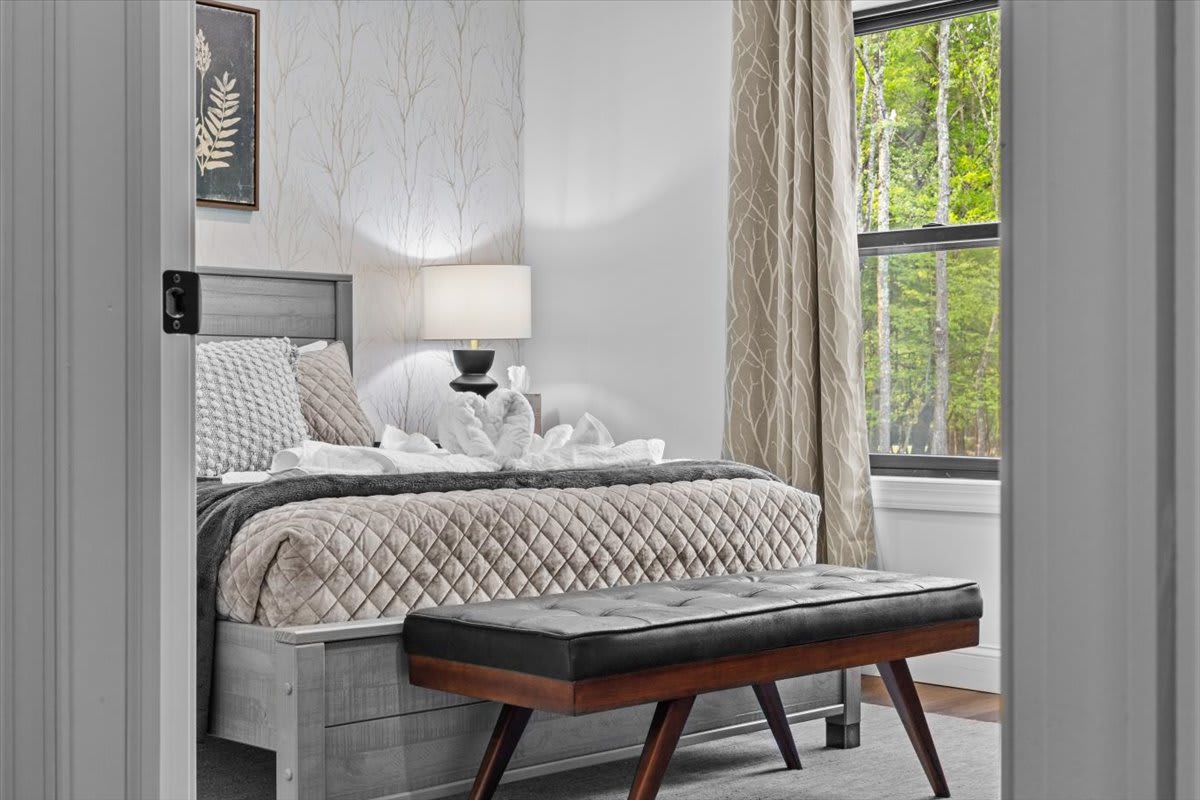 Sunlight streams through large windows in this peaceful queen bedroom retreat.