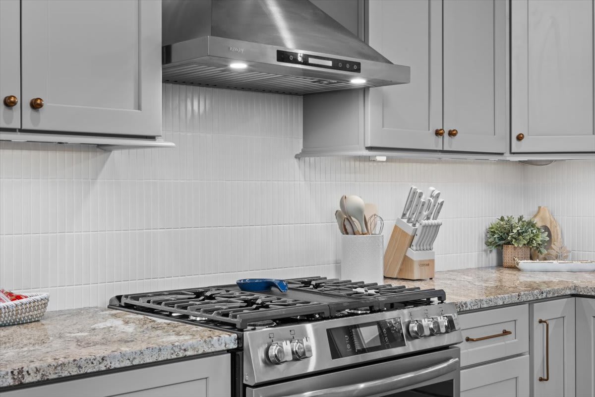 The gas range and stainless hood are ready for your home-cooked meals.