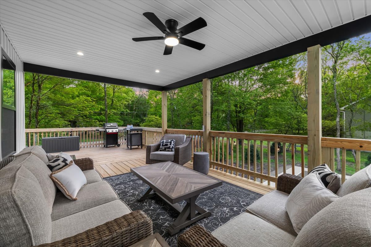 Gather on the spacious deck with plenty of seating and views of the trees.