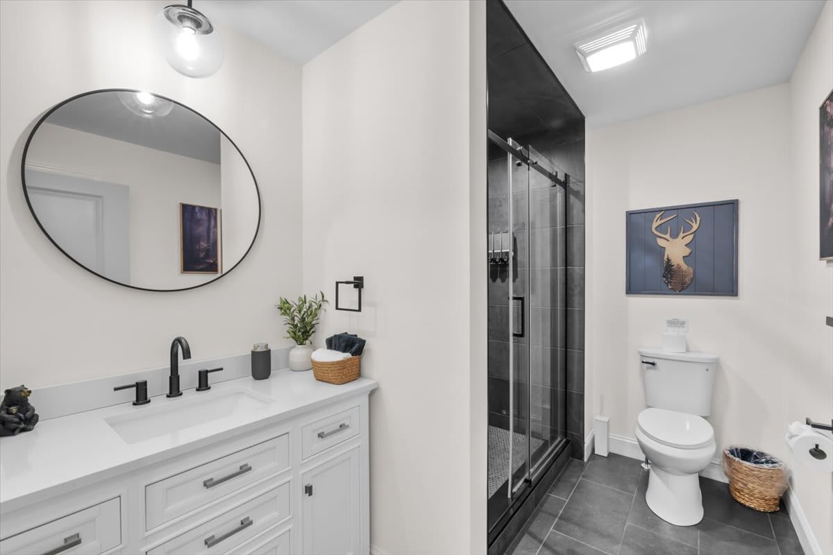 The modern bathroom features a walk-in shower and stylish black fixtures.