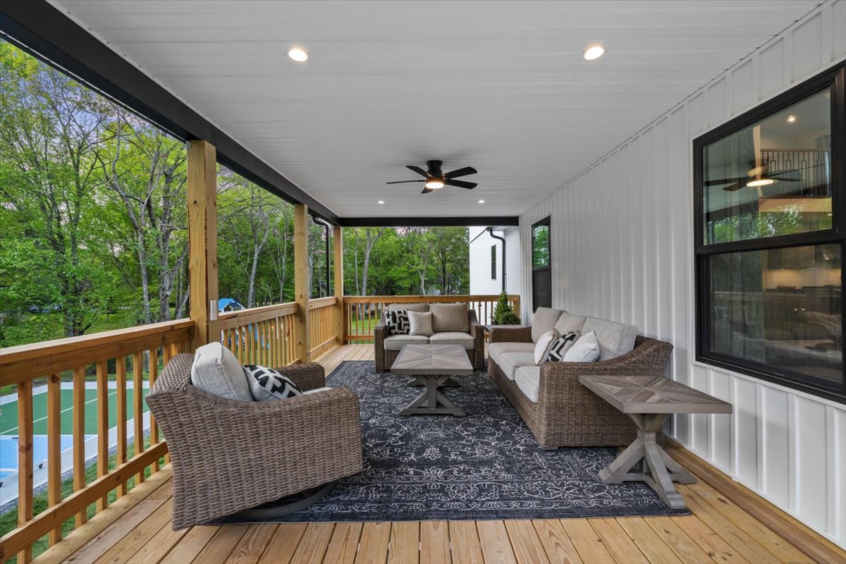 Relax under the covered deck with ceiling fans and comfortable seating.