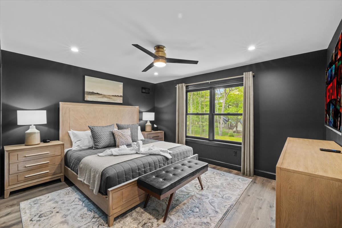 Dark accent walls and a king bed create a cozy retreat in the third bedroom.