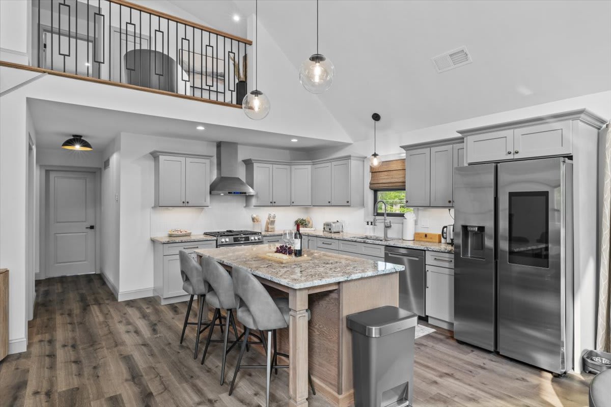 The chef's kitchen features a large island with bar seating and stainless appliances.
