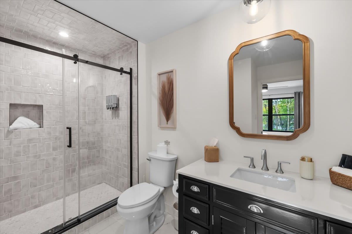 Freshen up in the elegant bathroom featuring a vintage gold mirror and crisp white vanity.