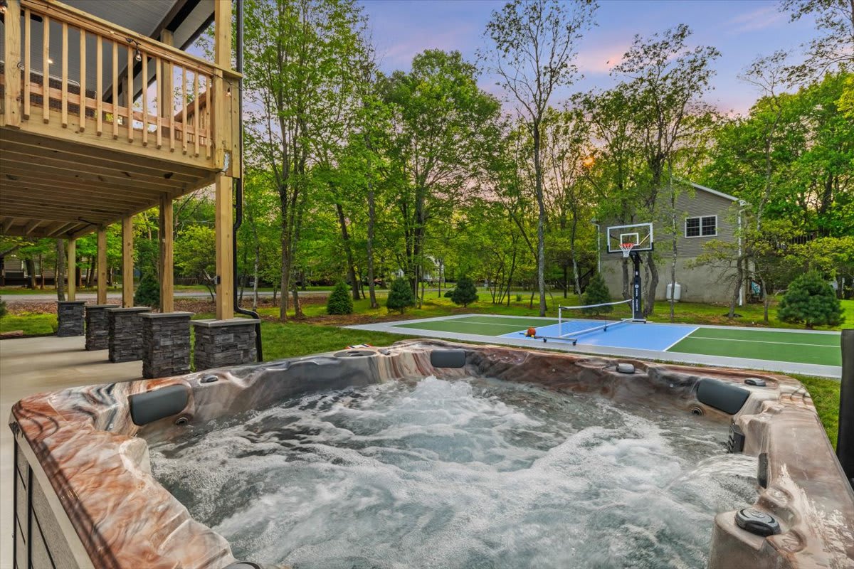Soak in the hot tub after a friendly pickleball match on the backyard court.