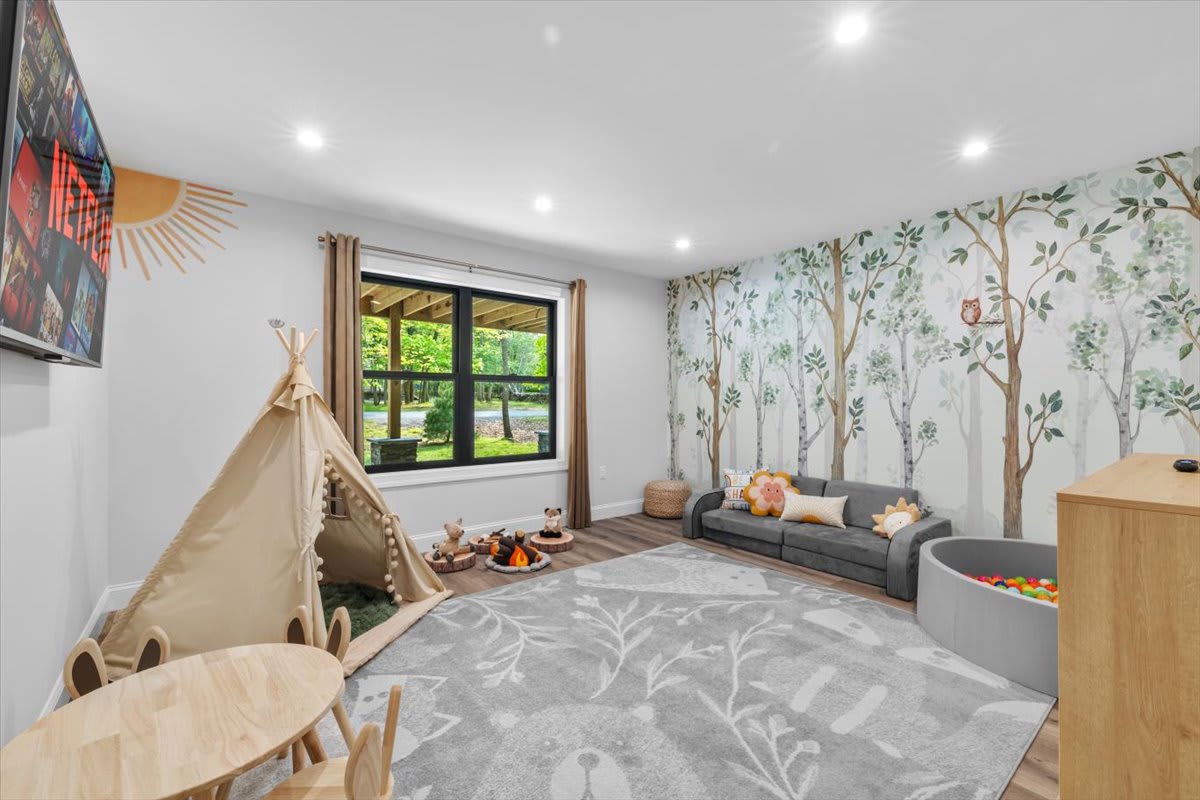 The charming playroom features floral wallpaper and cozy reading nooks for little adventurers.