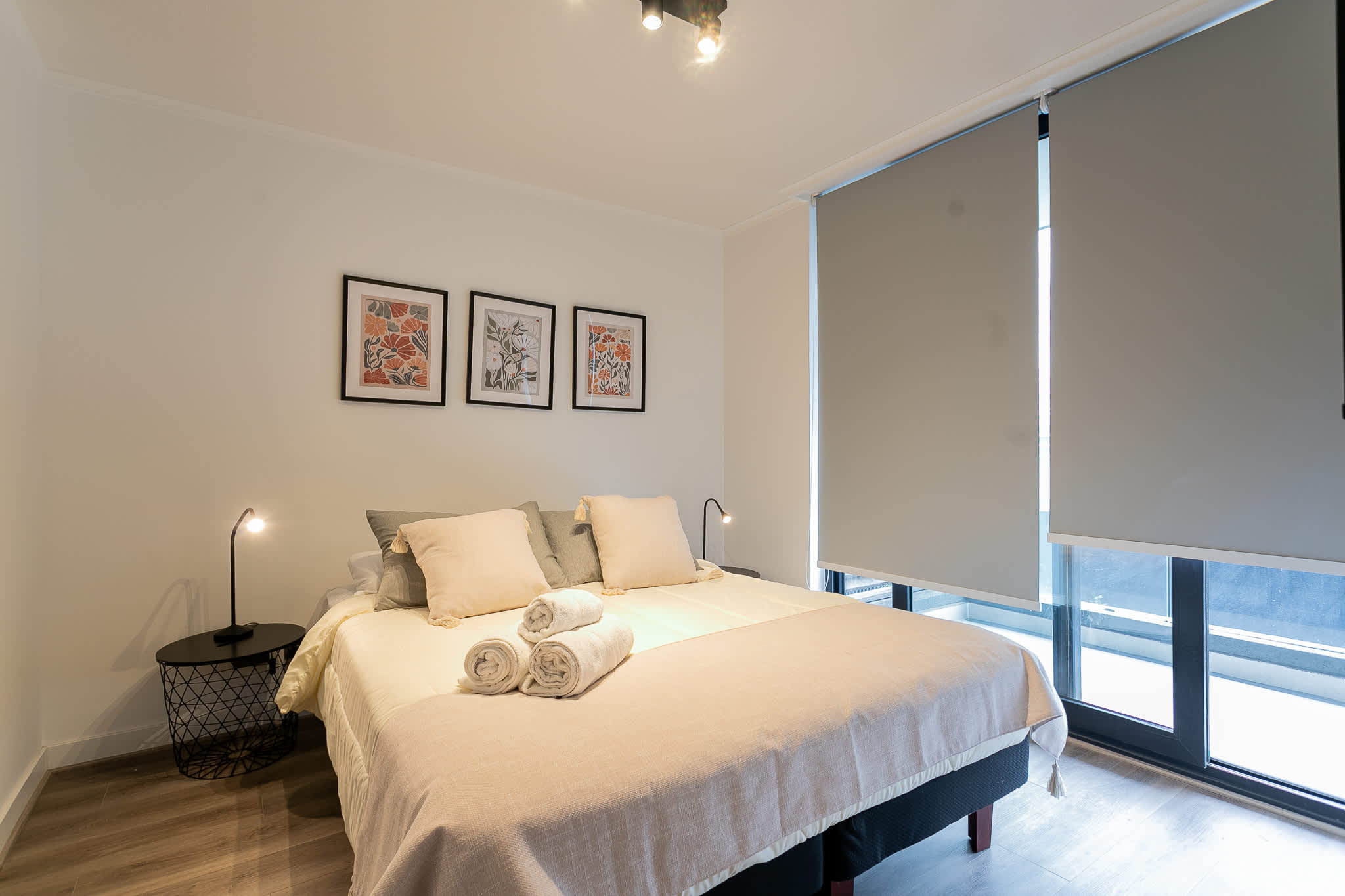 Relax in this cozy bedroom with modern decor and soft lighting, perfect for a restful night's sleep.