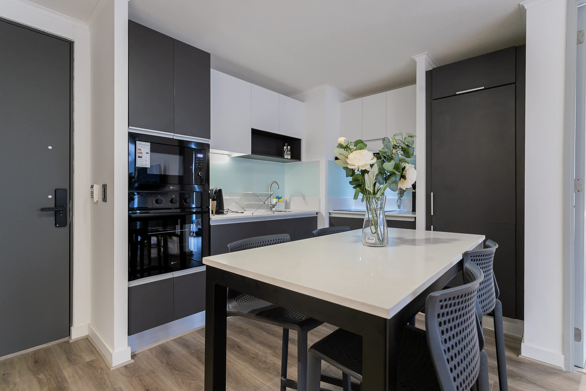 Experience culinary delight in this sleek, modern kitchen with elegant finishes and a cozy dining area.