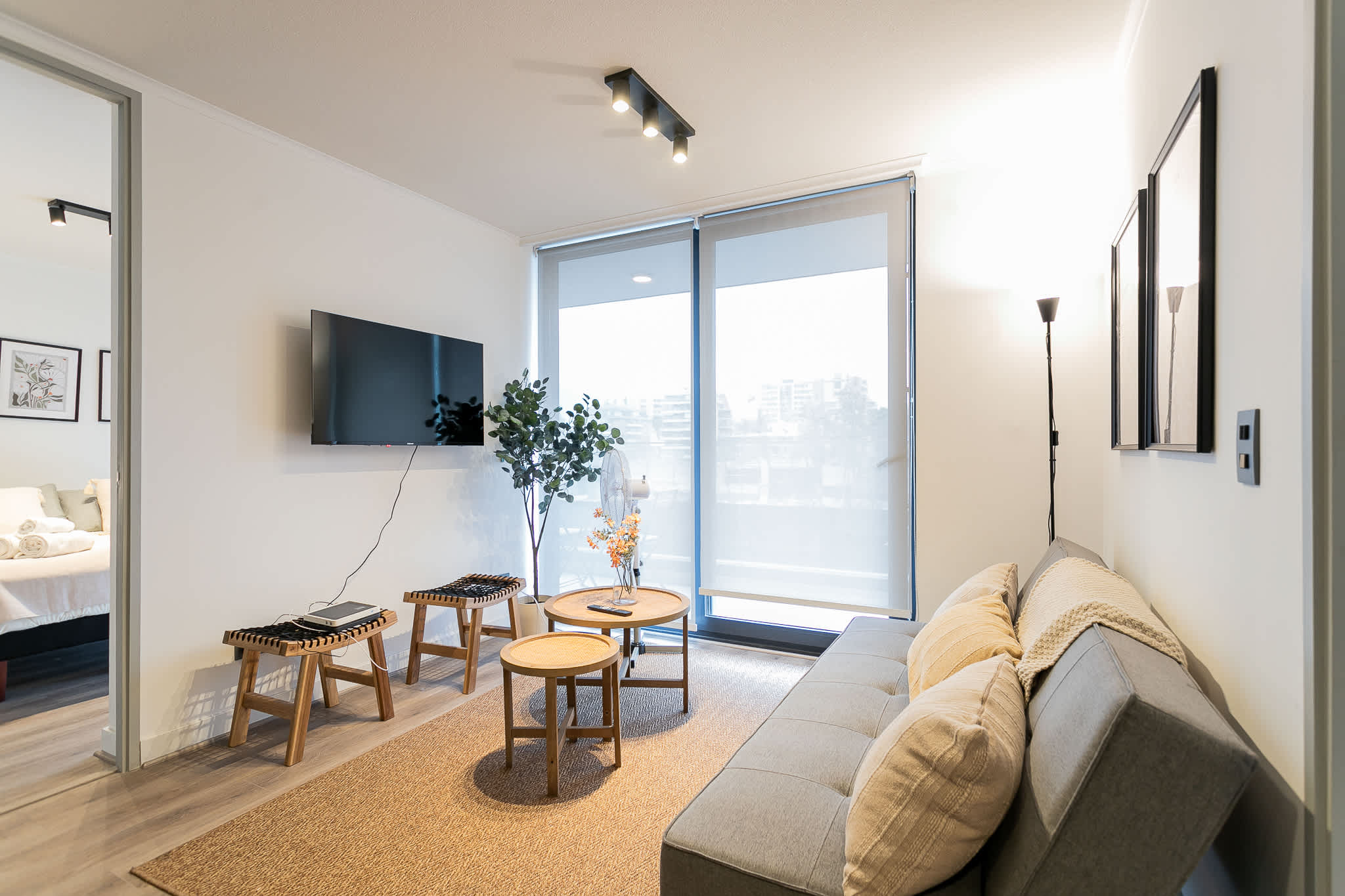 Relax in this modern living room with natural light, cozy seating, and a sleek design—perfect for unwinding after a day of exploring.