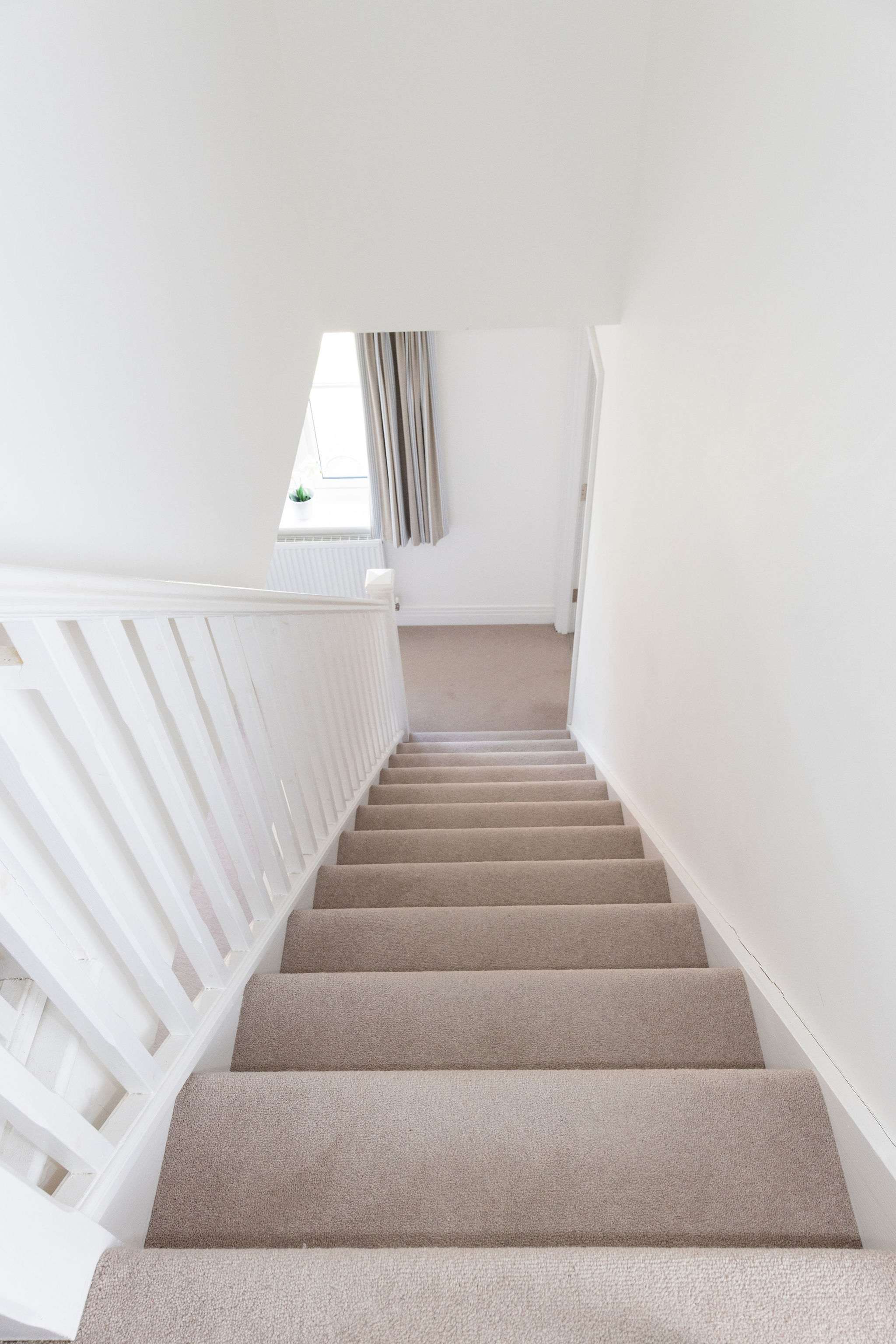 A bright, carpeted staircase leading to the upper floor.