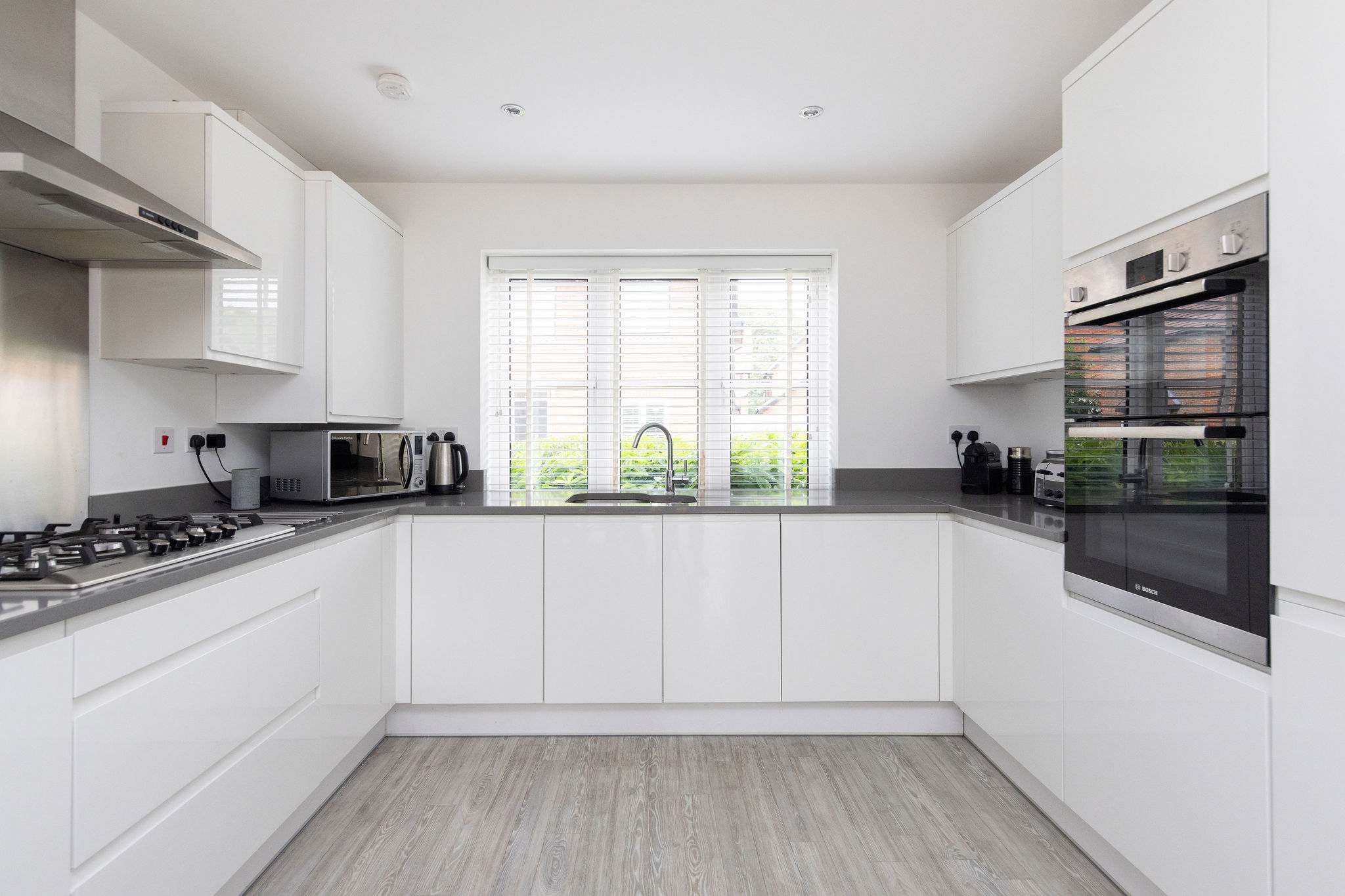 The bright and spacious kitchen is fully equipped with modern appliances, including a double oven and plenty of countertop space.