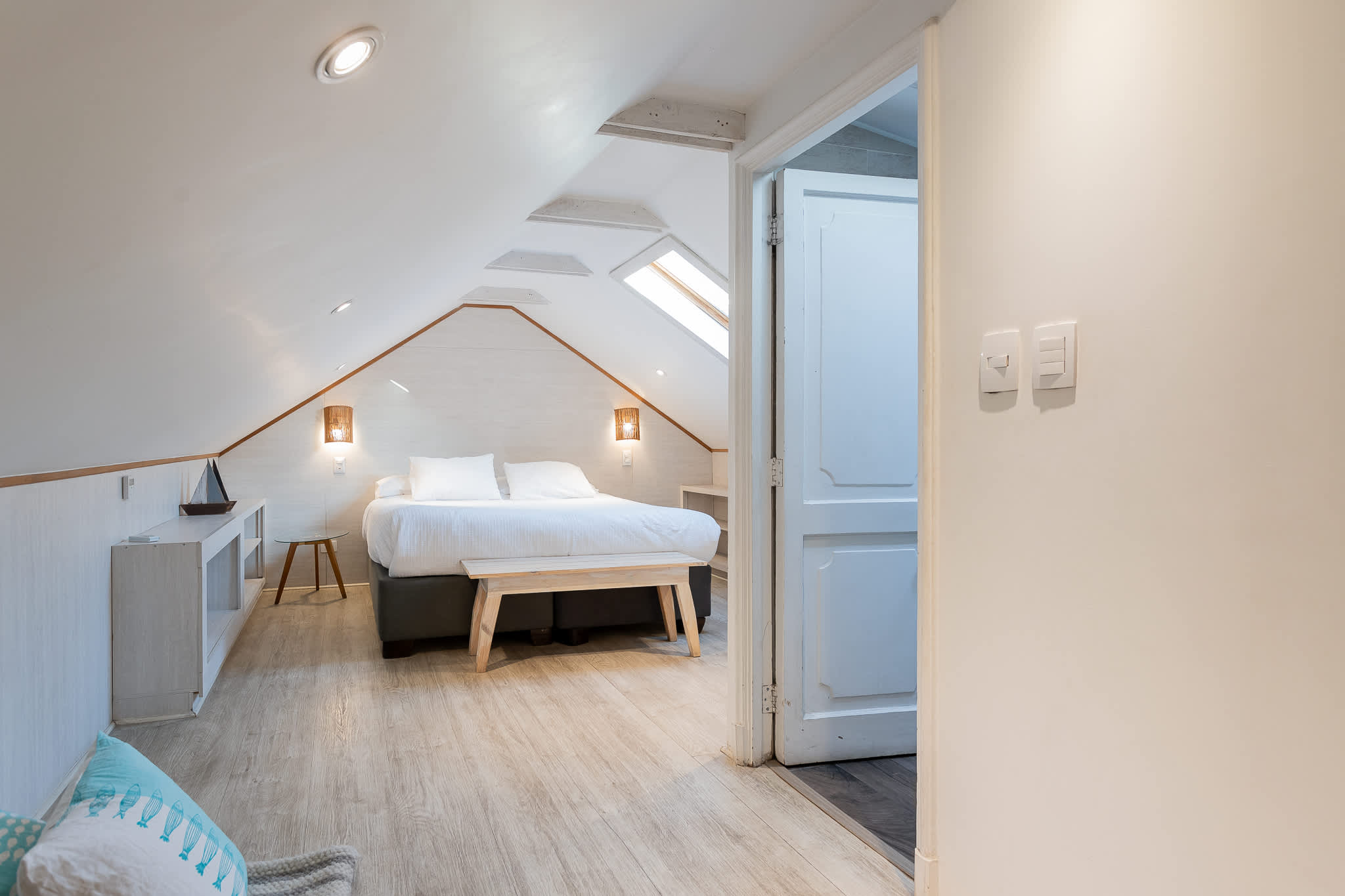 Cozy attic retreat with skylights and a plush double bed, perfect for a serene getaway.