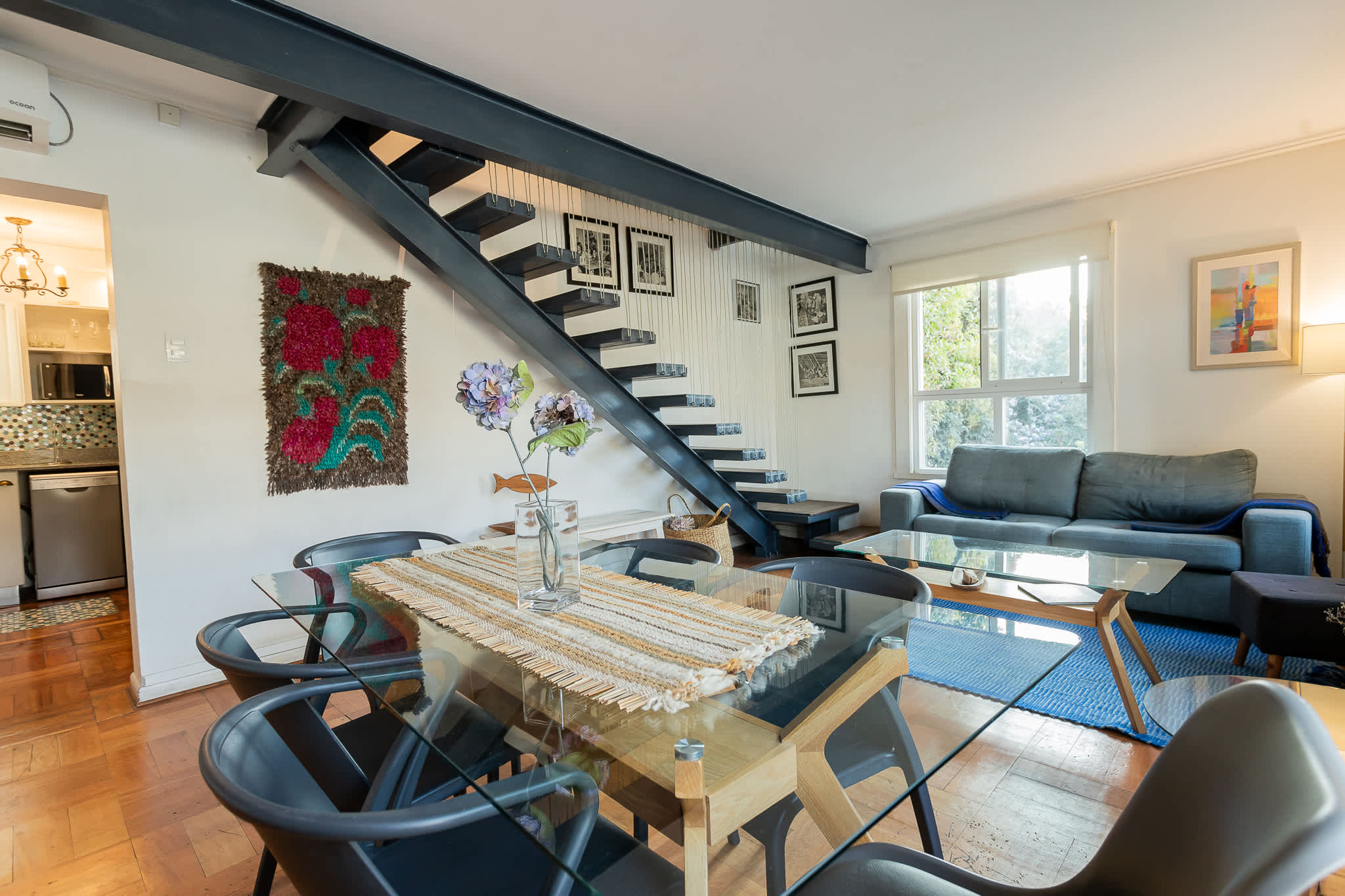 Stylish open-plan living space with modern decor and abundant natural light, perfect for relaxation and dining.