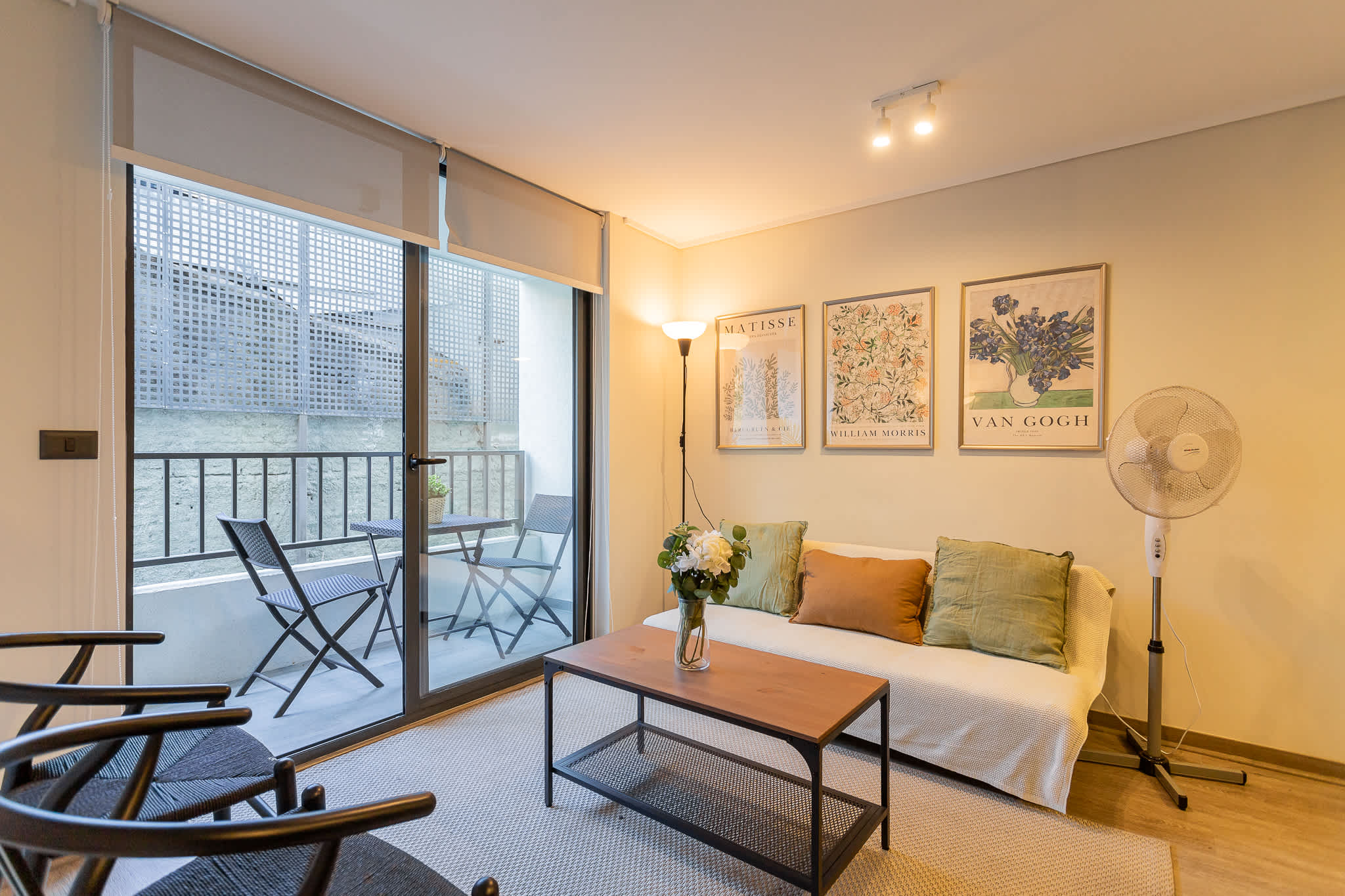 Relax in this cozy living space with stylish decor and a charming balcony view, perfect for unwinding after a day exploring the city.