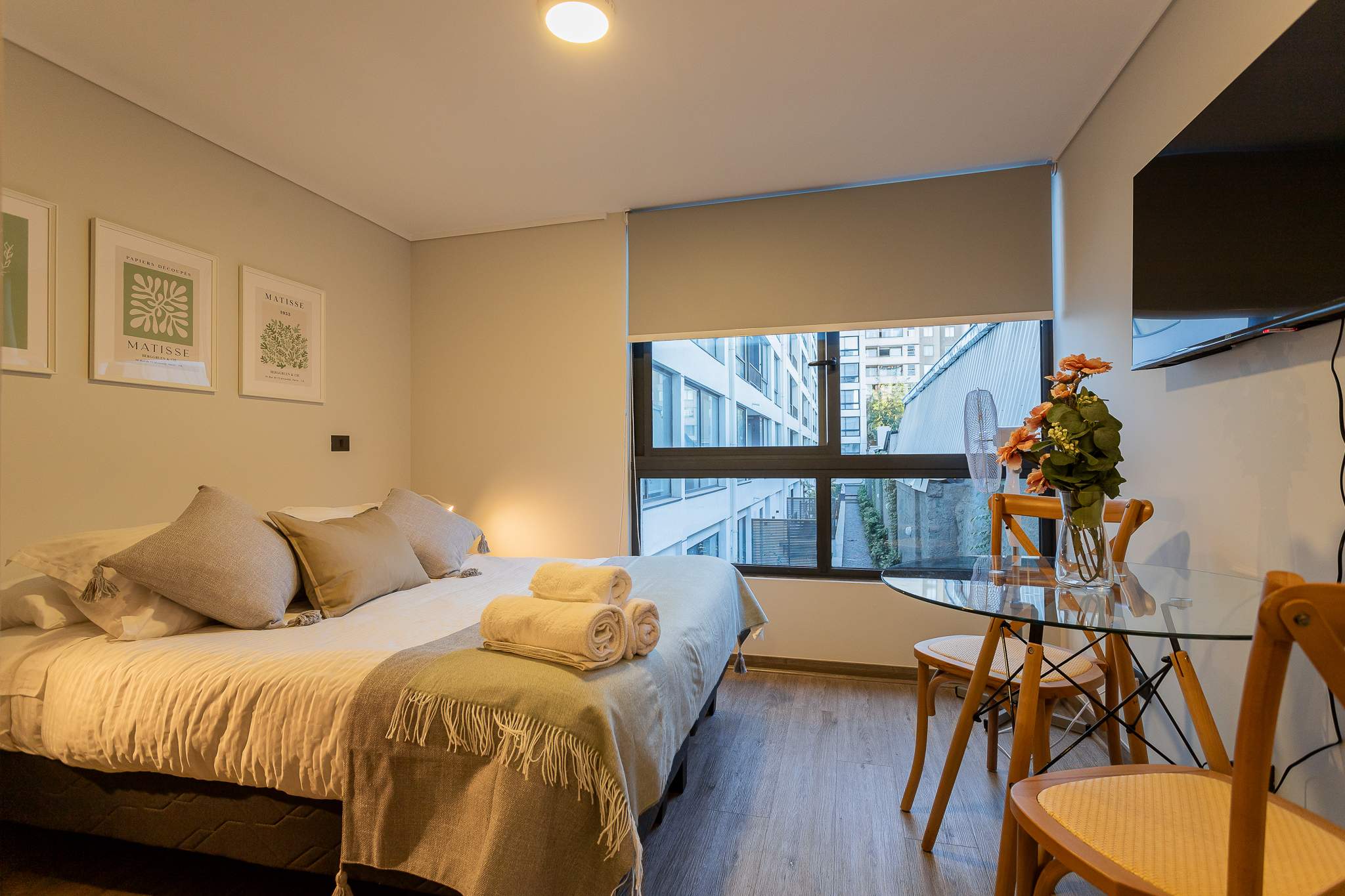 Experience comfort in this stylish studio with modern decor, a cozy bed, and a charming dining area, perfect for a relaxing stay.