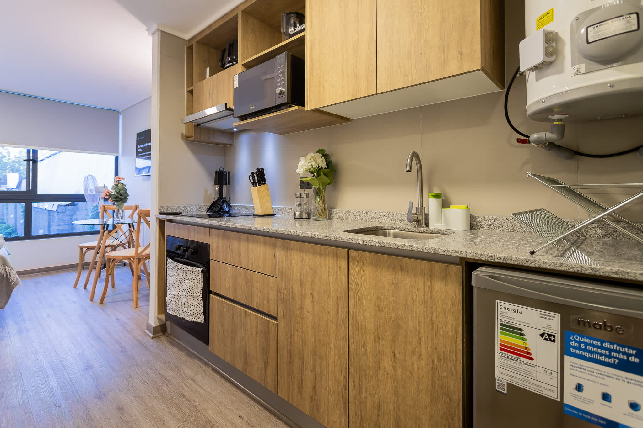 Chic studio kitchen with modern amenities and a cozy dining area, perfect for intimate meals.