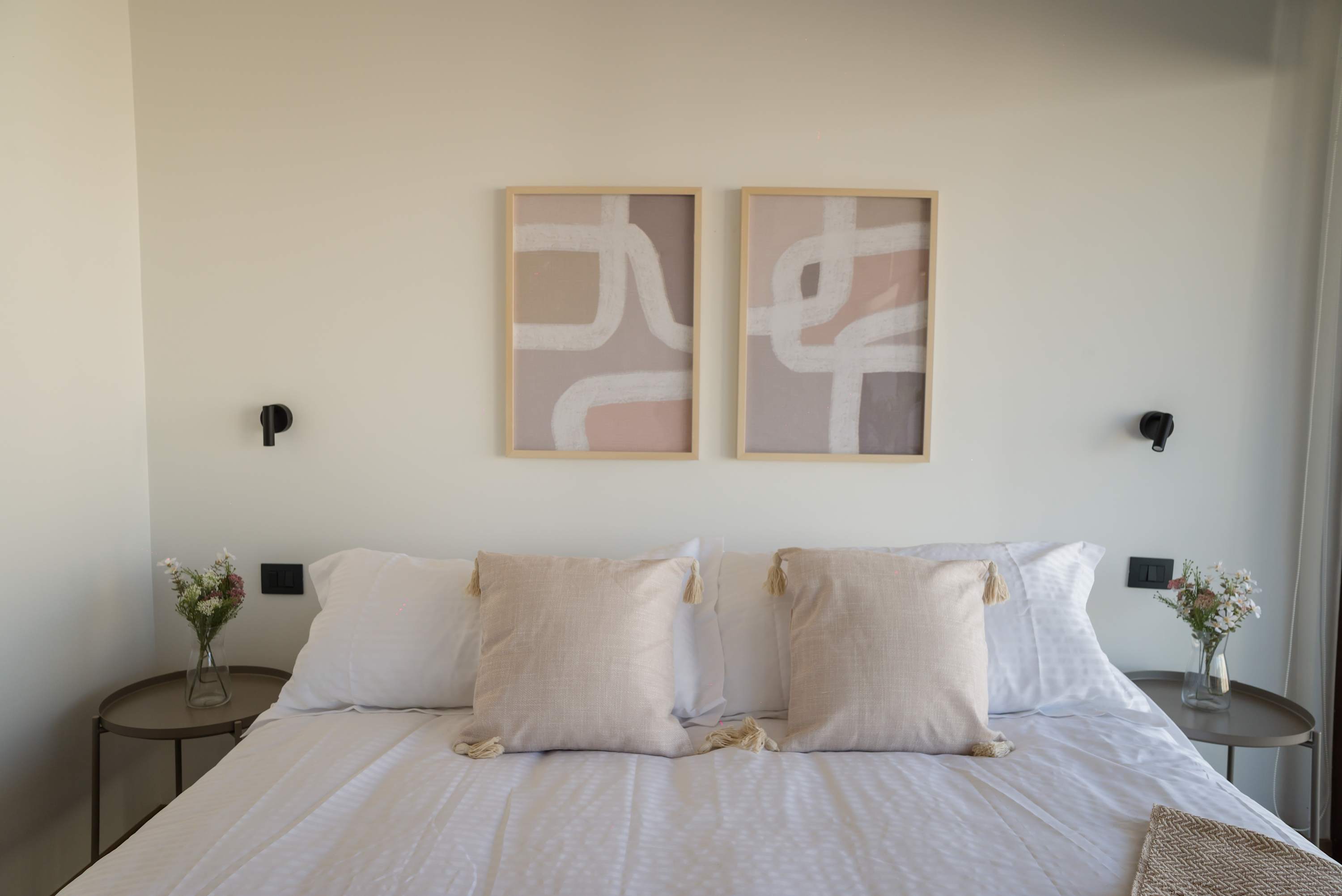 Relax in this cozy bedroom with elegant decor and soothing neutral tones, perfect for a restful night's sleep.