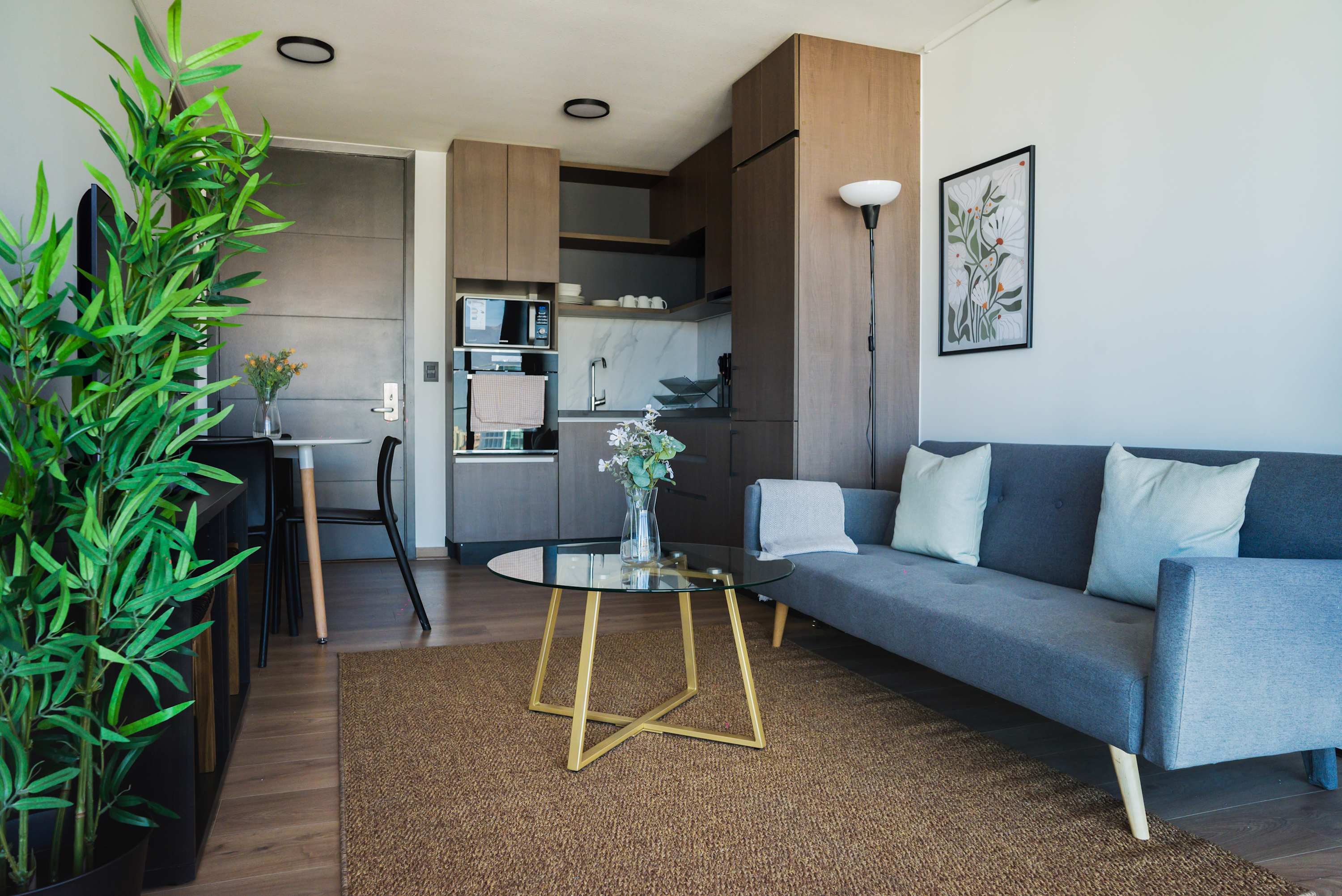 Chic and cozy living area with modern design and lush greenery, ideal for a relaxing urban retreat.