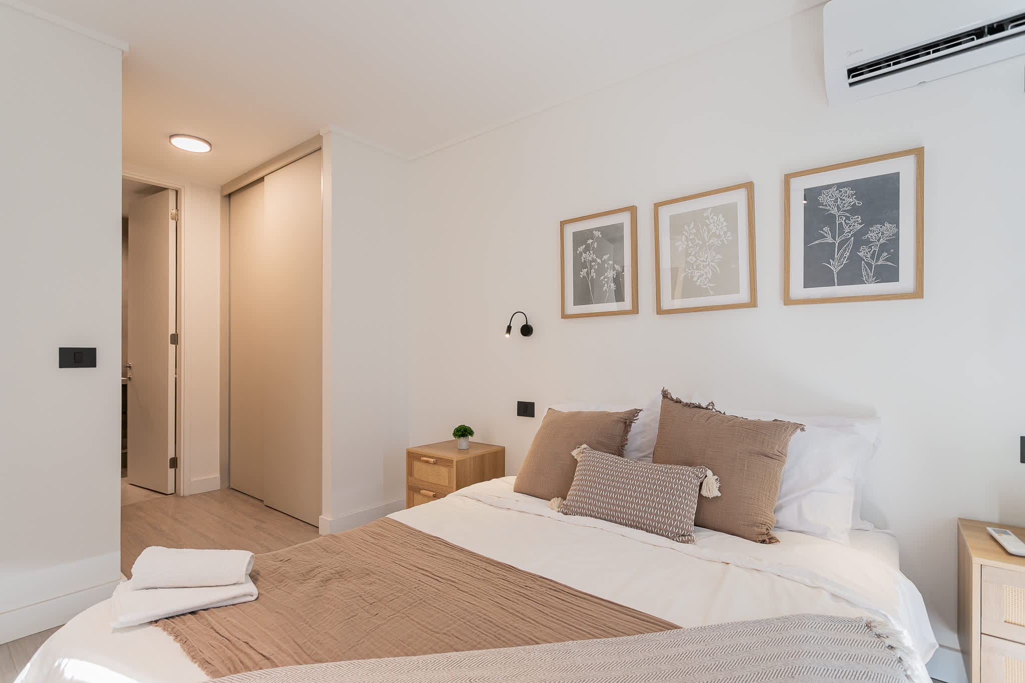 Relax in this serene bedroom with cozy bedding and calming botanical decor, perfect for a restful stay.