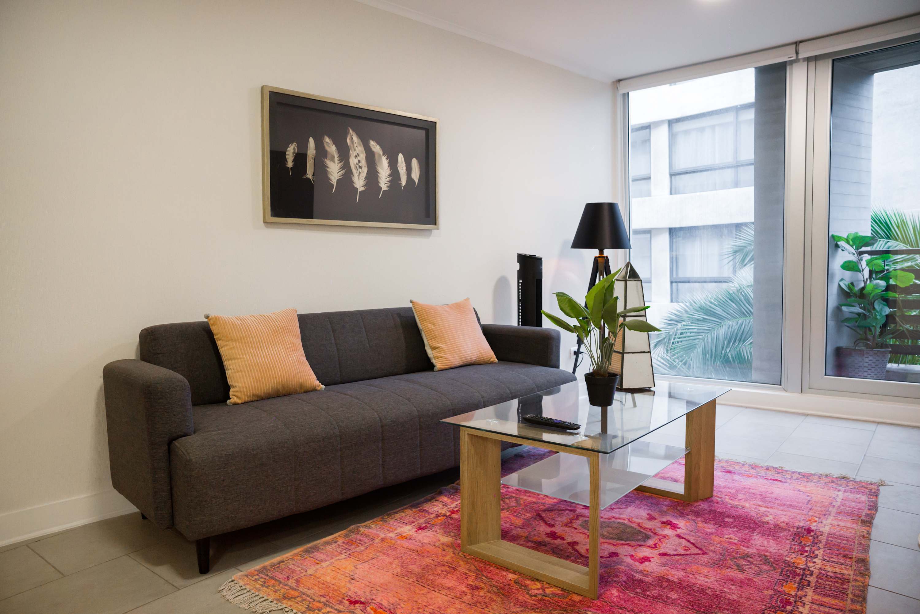 Relax in this stylish living room with a cozy sofa, vibrant decor, and plenty of natural light.