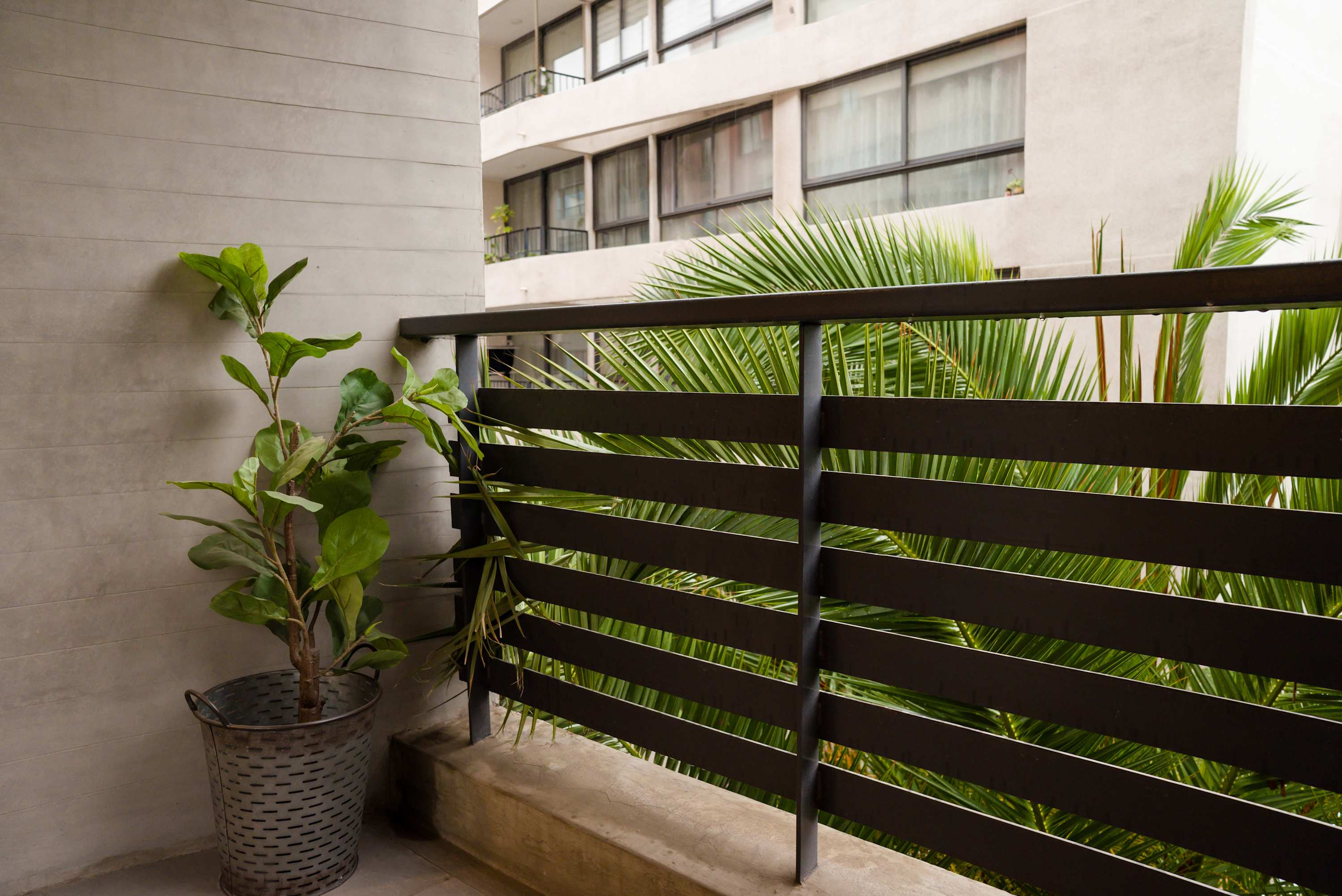 Relax on your private balcony with lush greenery and urban views, perfect for unwinding after a day in the city.