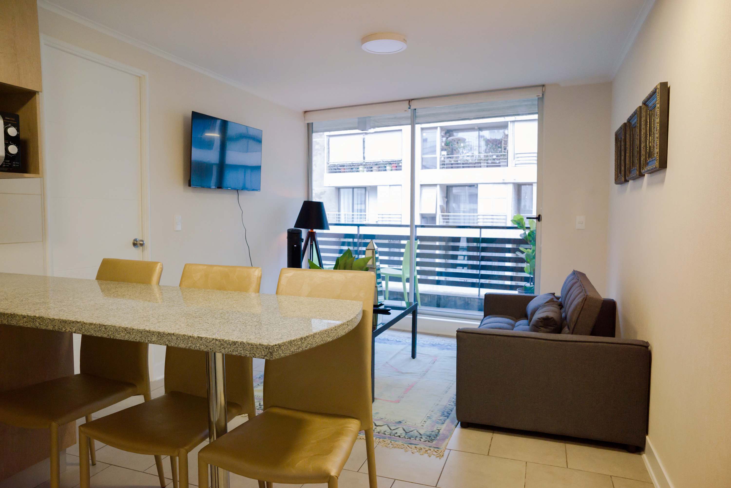 Cozy living space with a modern touch, featuring a comfy sofa and a balcony view perfect for relaxation.