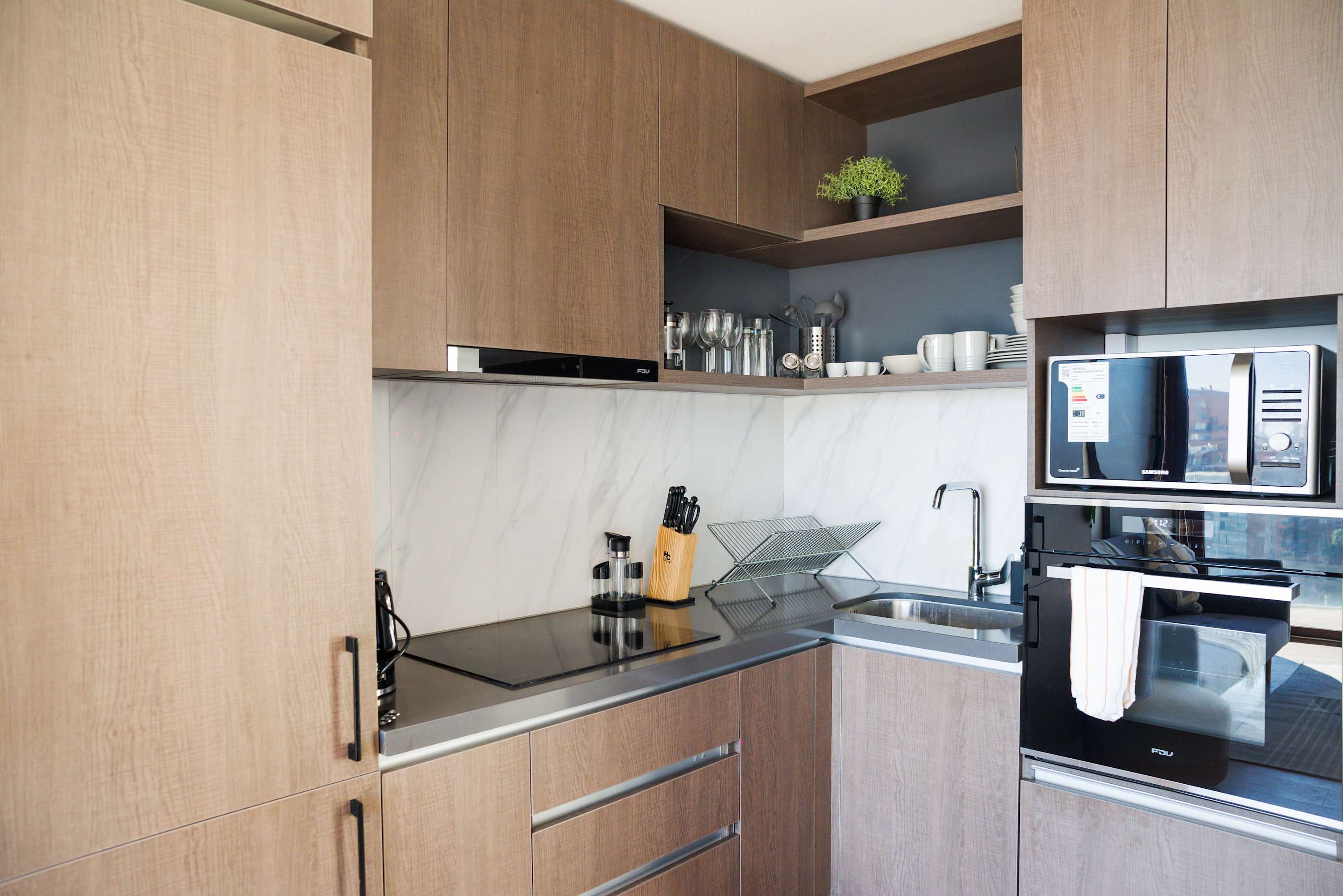 Sleek and modern kitchen with top-notch appliances and stylish wooden cabinetry, perfect for culinary adventures.