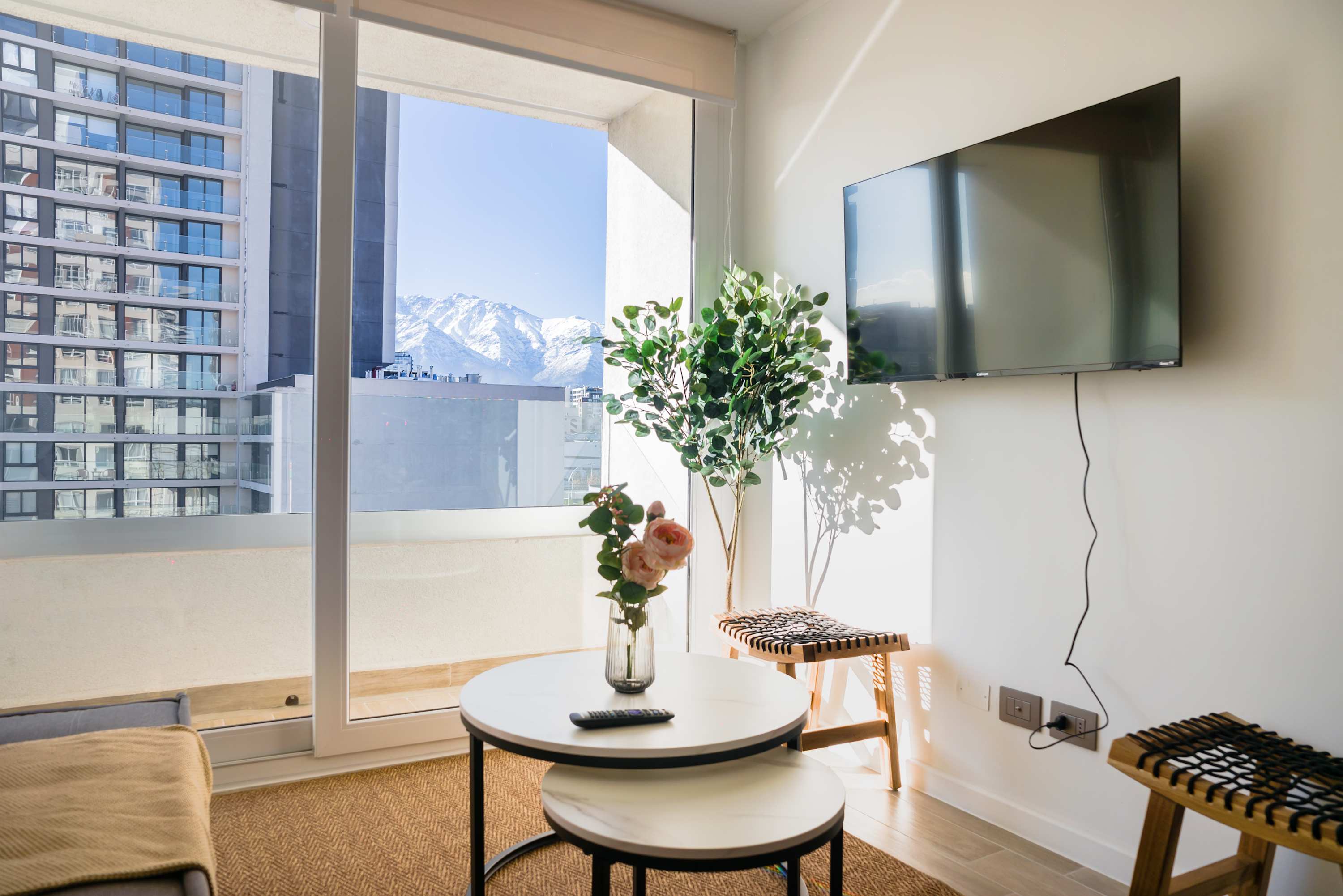 Relax in a bright living room with stunning city and mountain views, perfect for unwinding after a day of exploring.