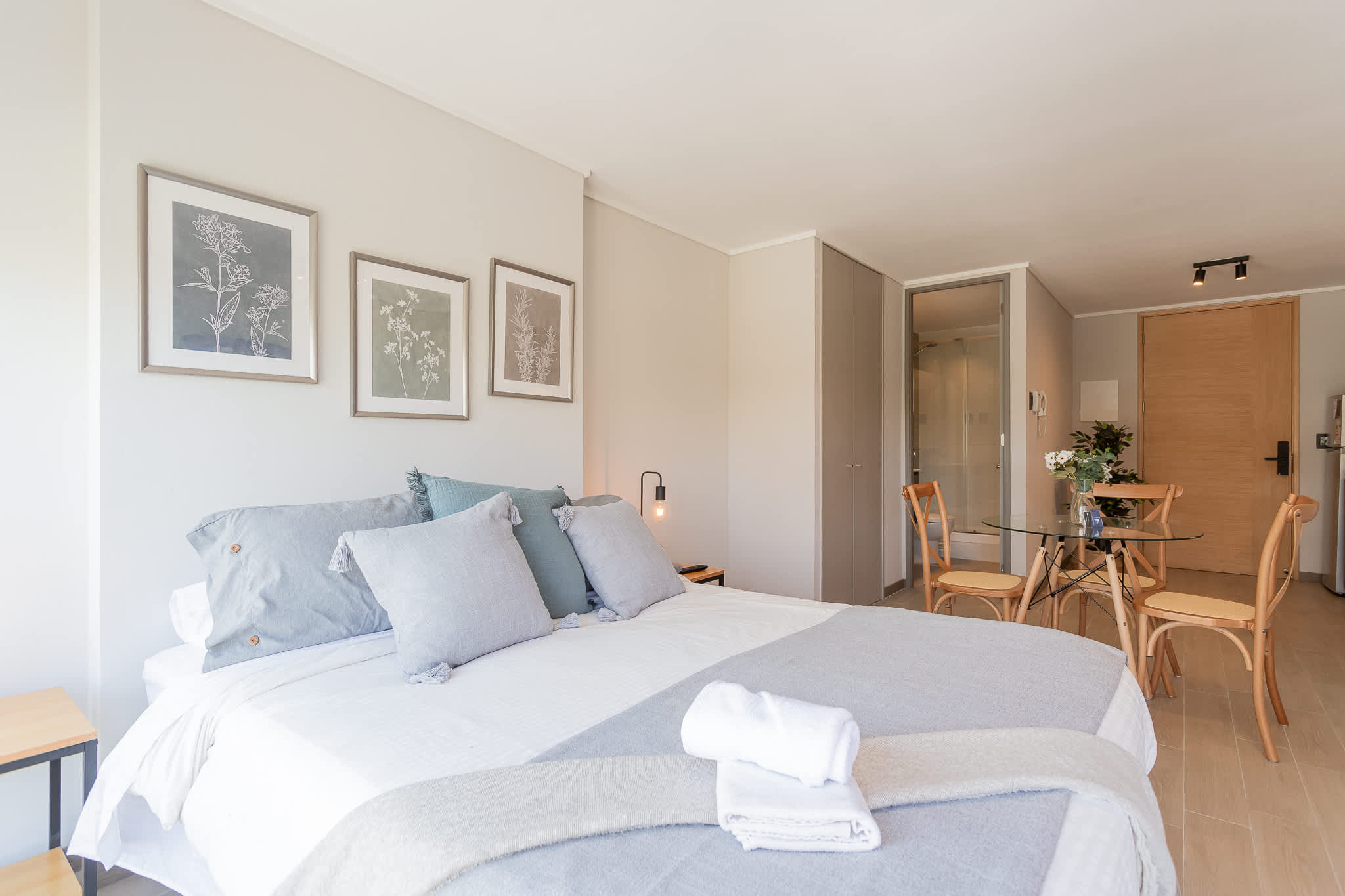 Bright and stylish studio with cozy bedding and a chic dining area, perfect for a relaxing stay in Chile.