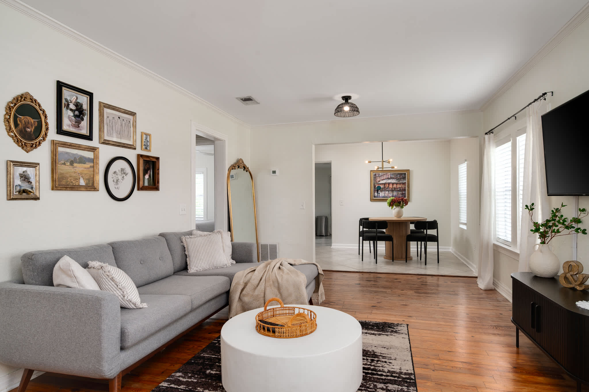 Relax in style in our inviting living room, featuring a comfortable gray sectional and charming decor, perfect for unwinding.