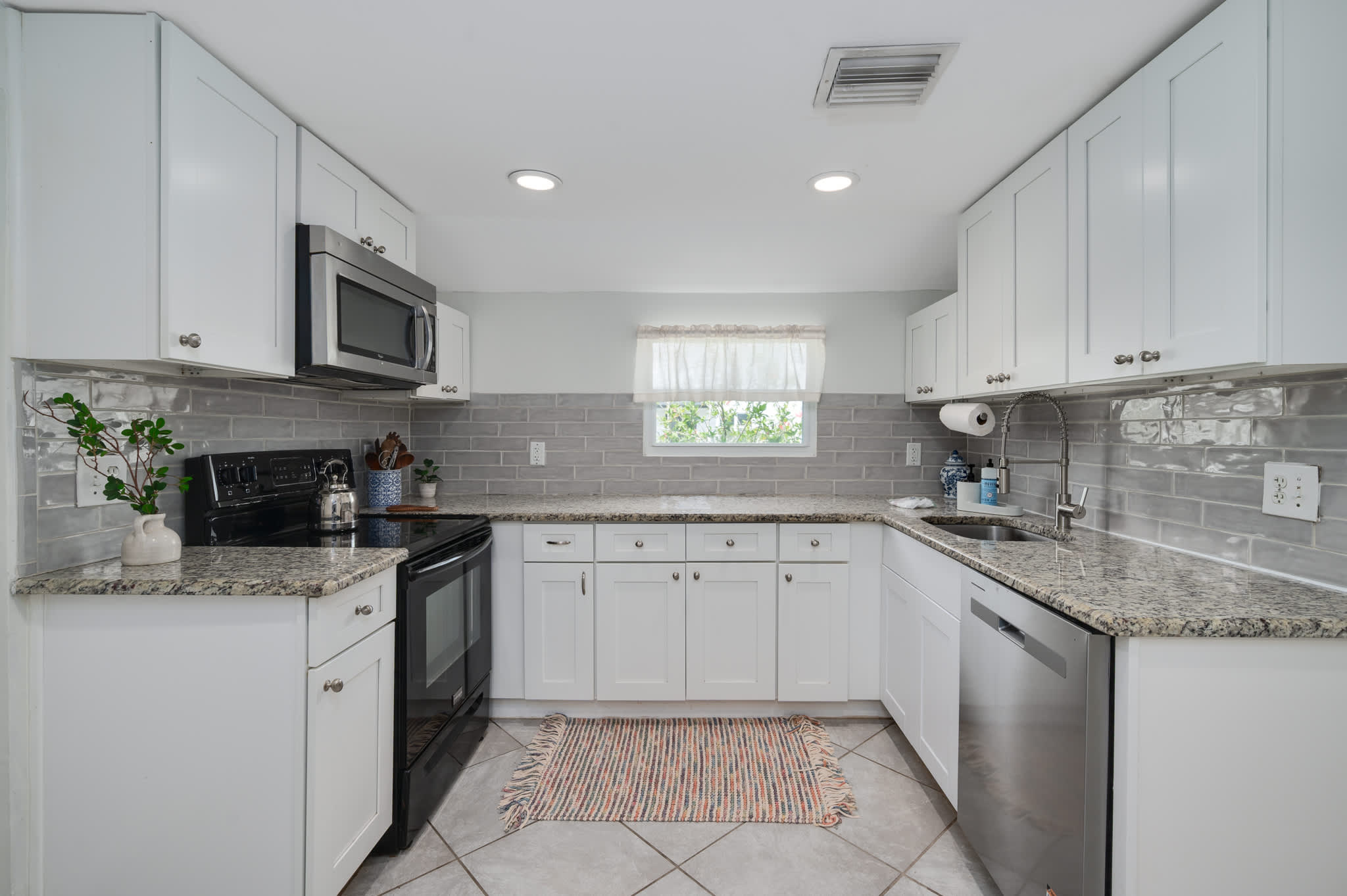 Whip up delicious meals in our bright, fully equipped kitchen, featuring modern white cabinetry, stainless steel appliances, and ample counter space!