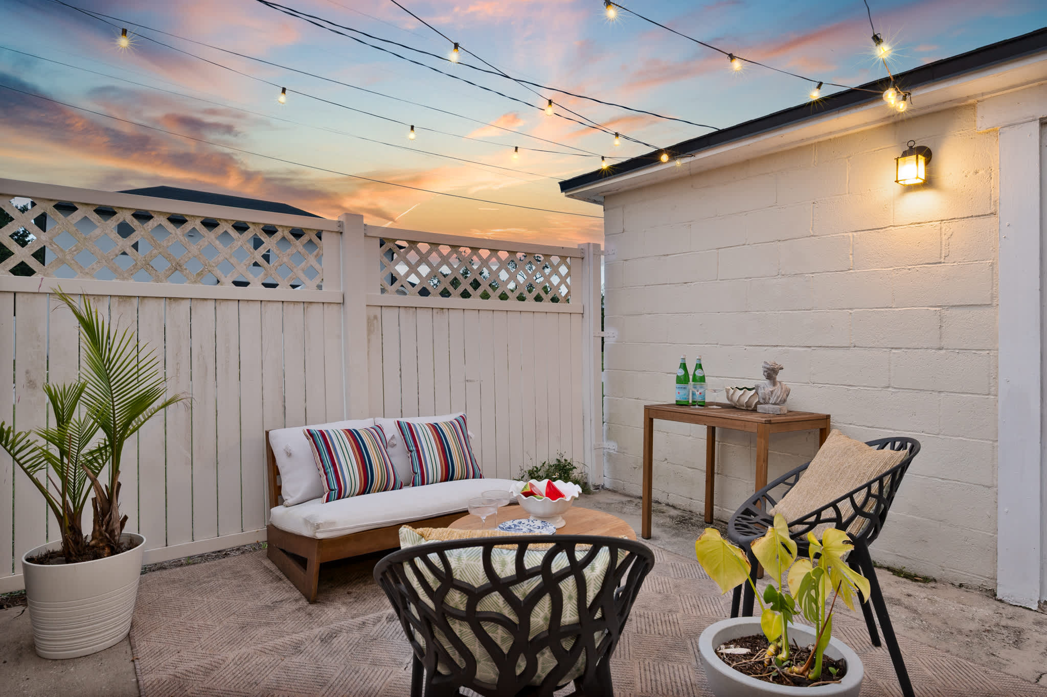 Your charming outdoor oasis: a private patio with string lights and comfortable seating for all to enjoy.