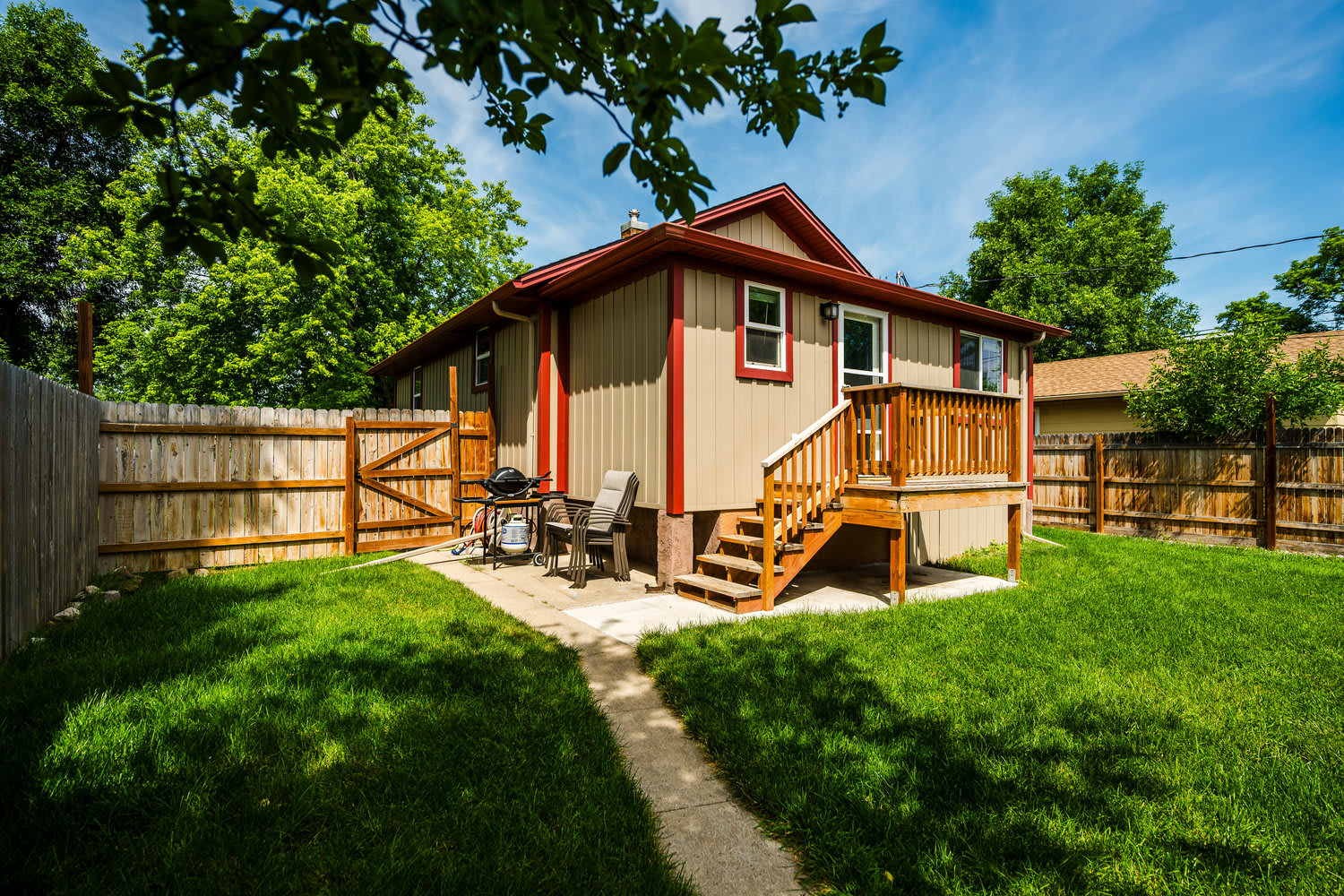 Fully fenced backyard at The Maple with deck and green grass — Sheridan, Wyoming