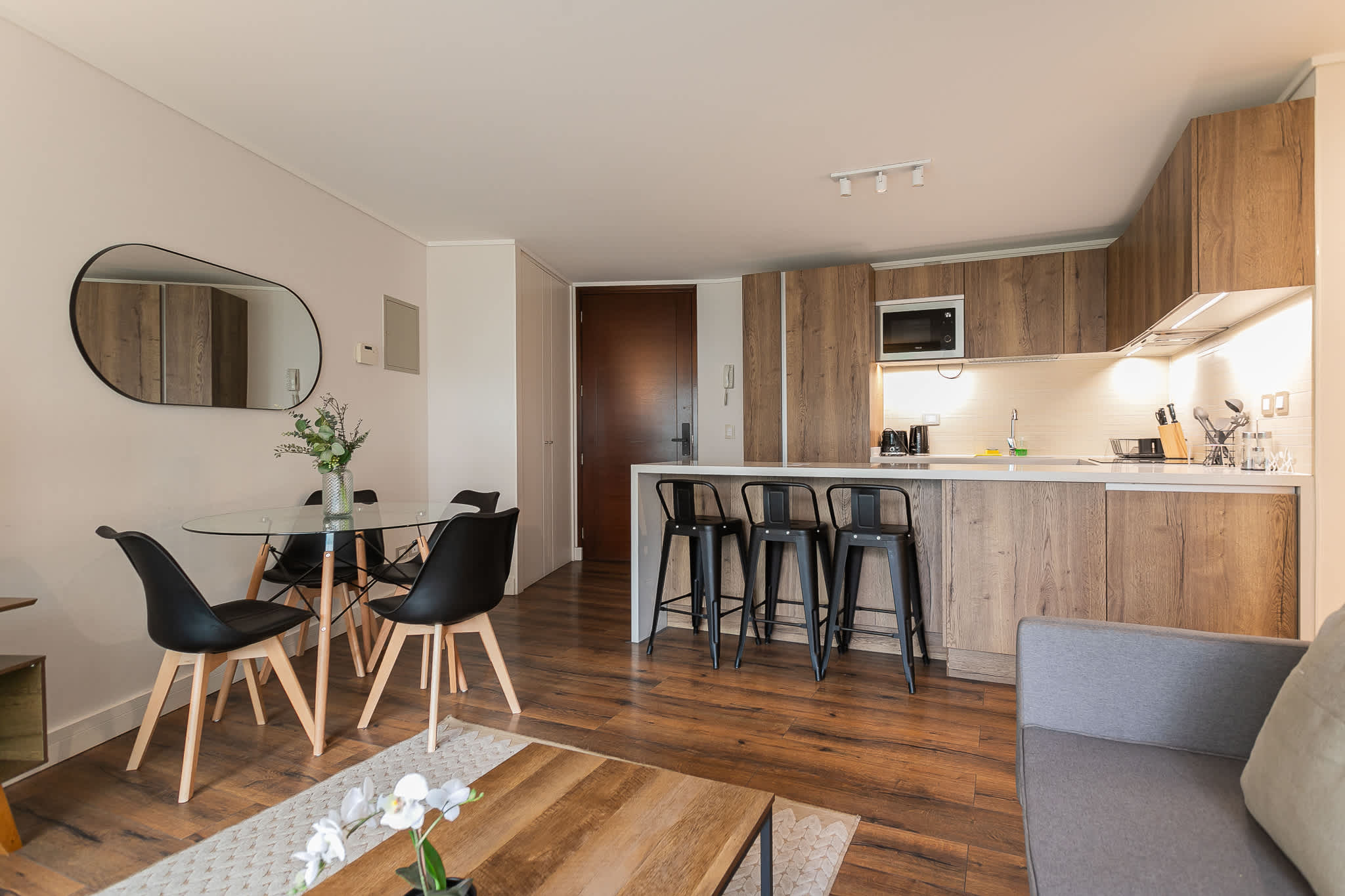 Chic and modern kitchen with stylish dining area, perfect for cozy meals and gatherings in this elegant Chilean apartment.