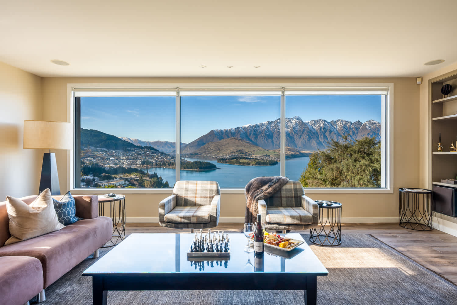 Gather with family or friends around the cozy gas fireplace in a modern, open-plan living space. Perfect for unwinding after a day of Queenstown adventures.