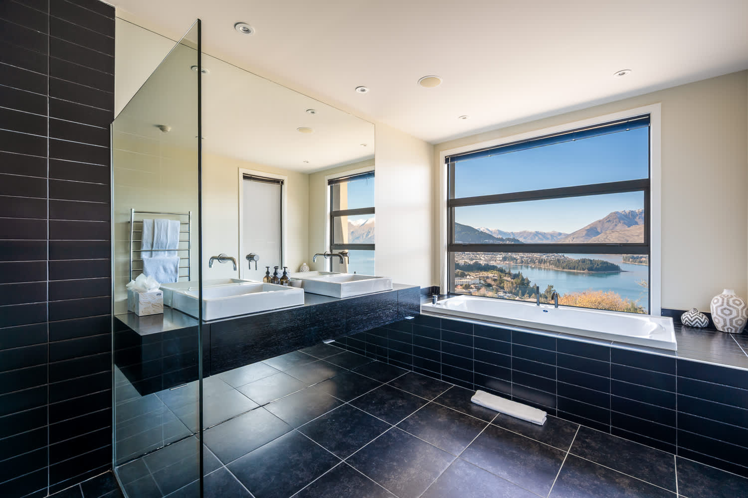 Experience luxury in the master ensuite, complete with premium fixtures and panoramic views of Lake Wakatipu. Natural light floods the space, creating a serene atmosphere for your Queenstown stay.