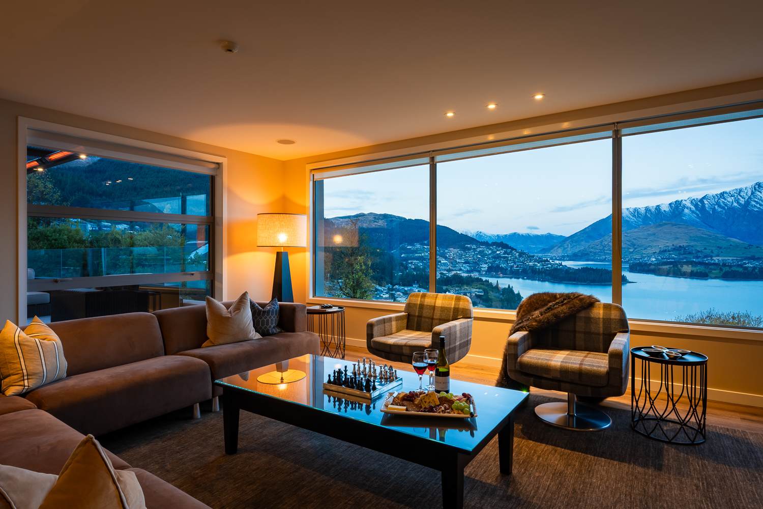 The spacious open-plan living area features modern décor and comfortable seating. It’s an inviting space for family and friends to gather in Queenstown’s luxury.