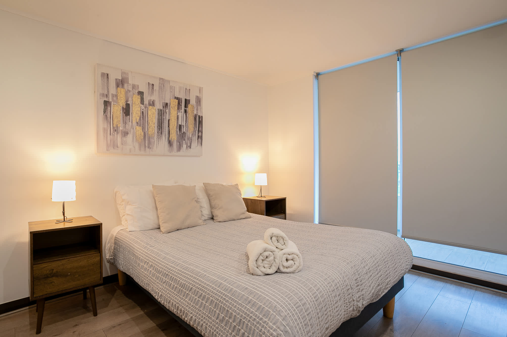 Relax in this cozy bedroom with modern decor and warm lighting, perfect for unwinding after a day of exploring.