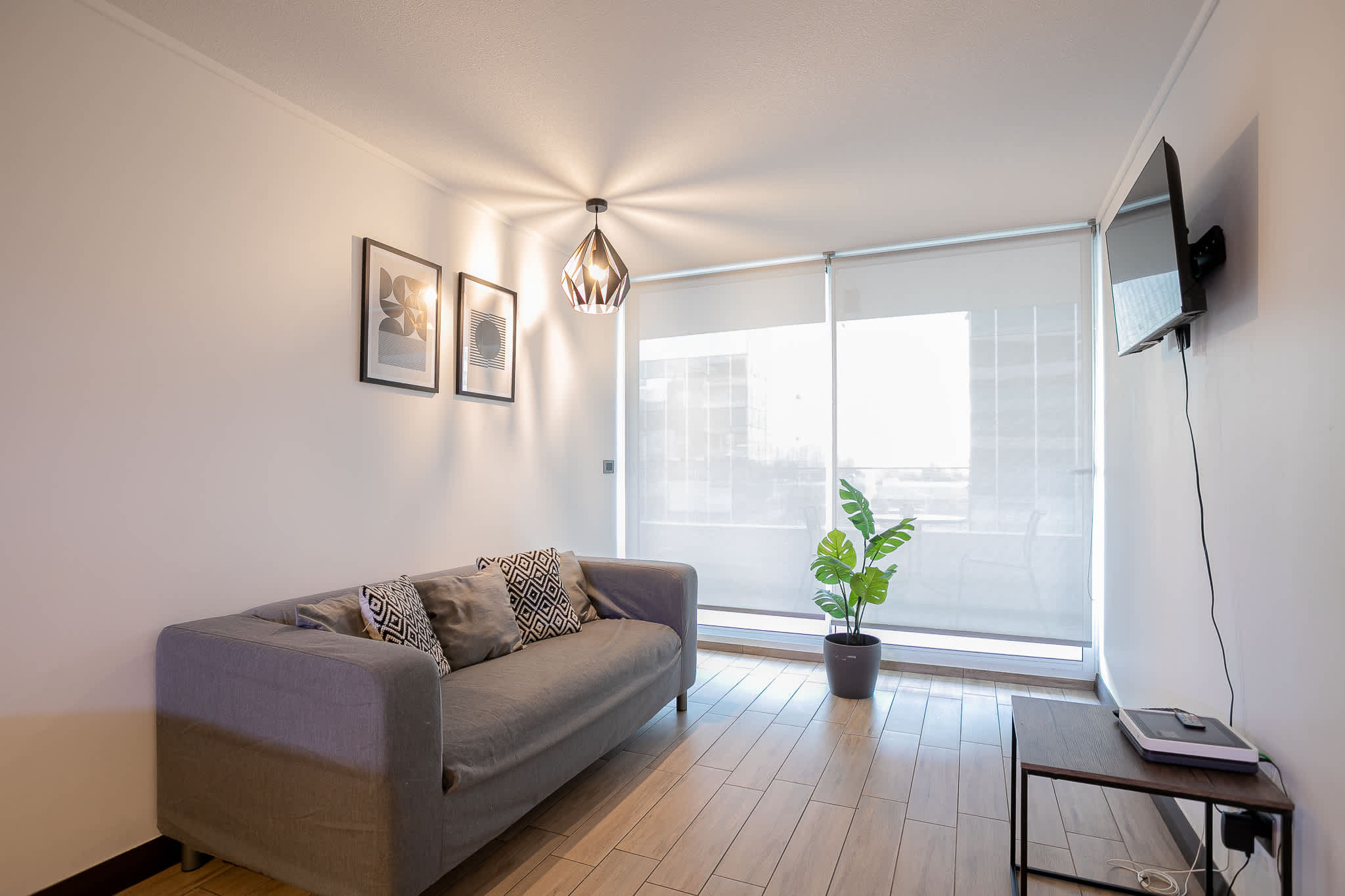 Relax in this bright and modern living room with a comfy sofa and natural light, perfect for unwinding after a day of exploring.