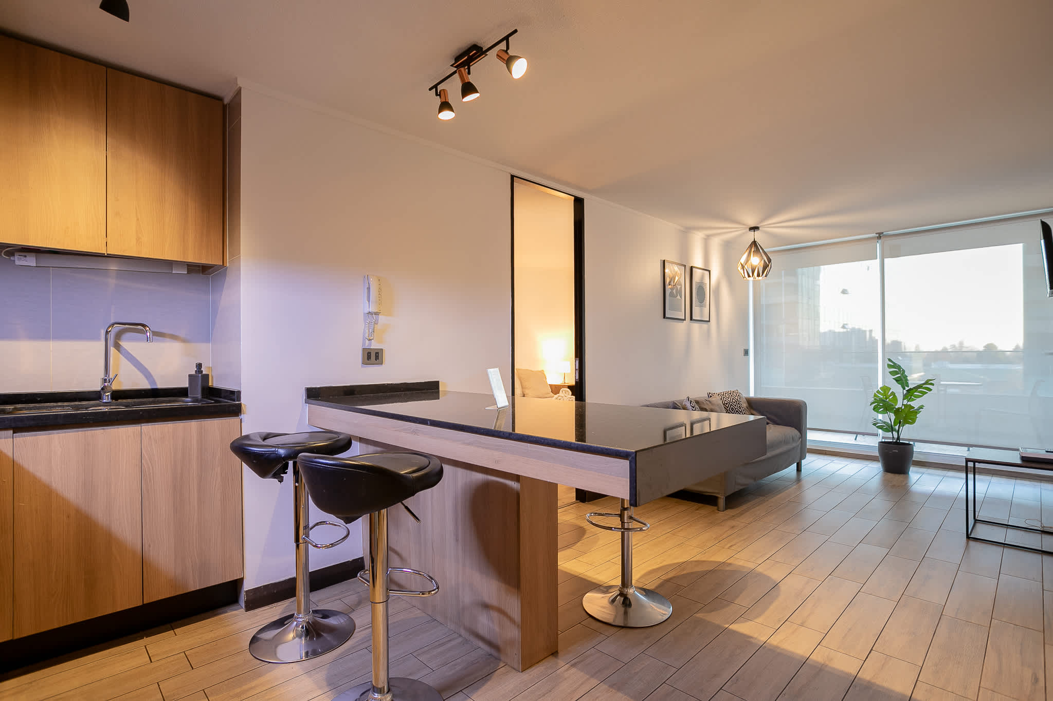 Stylish open-plan kitchen and living area with modern decor and natural light, perfect for a cozy stay.