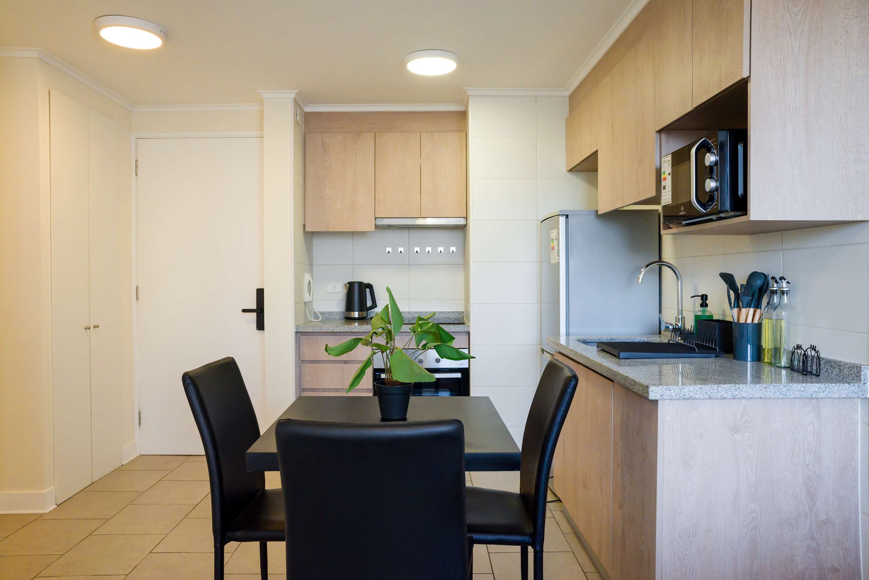 Cozy and modern kitchen with sleek appliances and a stylish dining area, perfect for intimate meals in the heart of the city.
