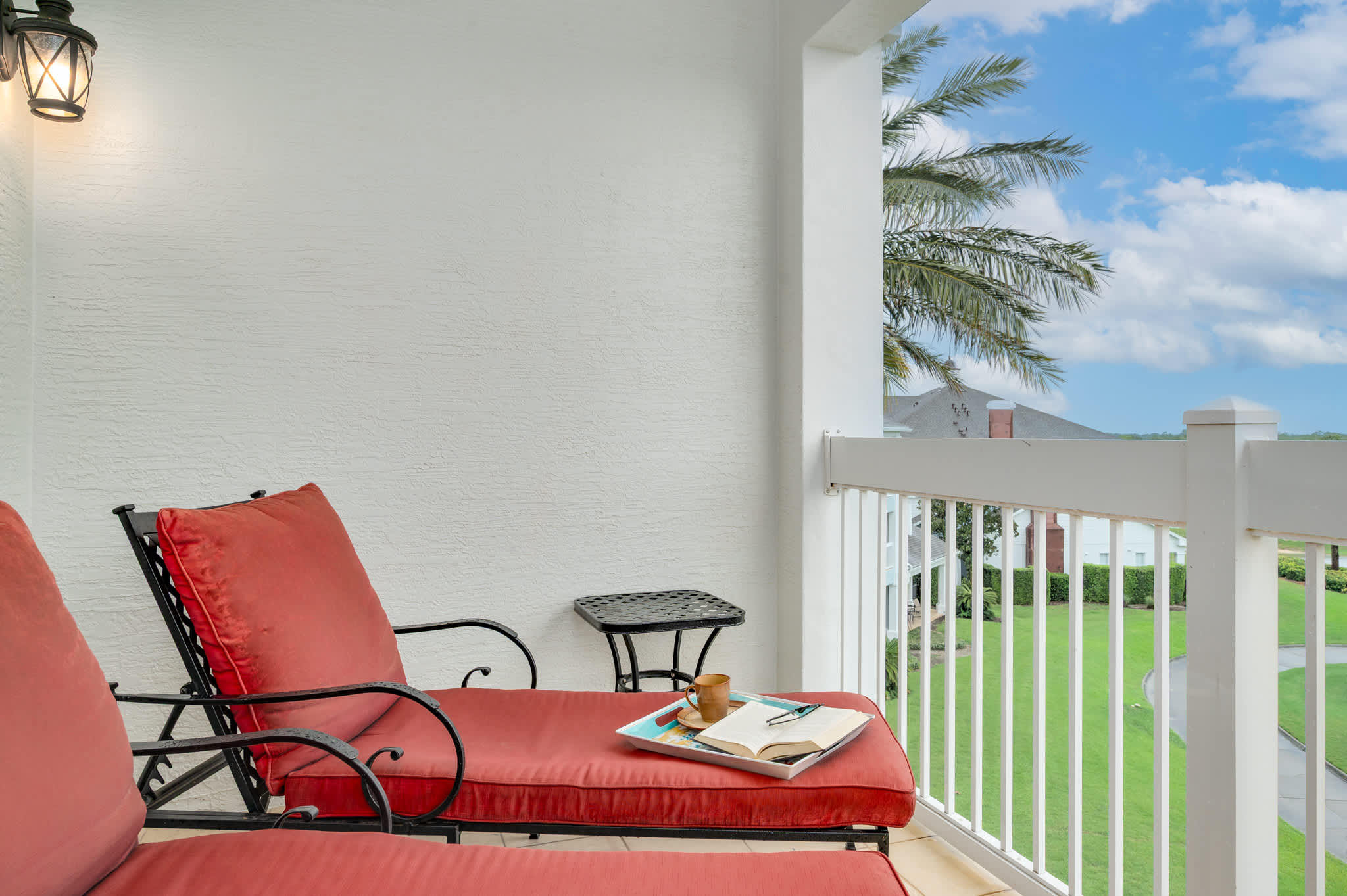 Private balcony with comfortable loungers and scenic golf course views.