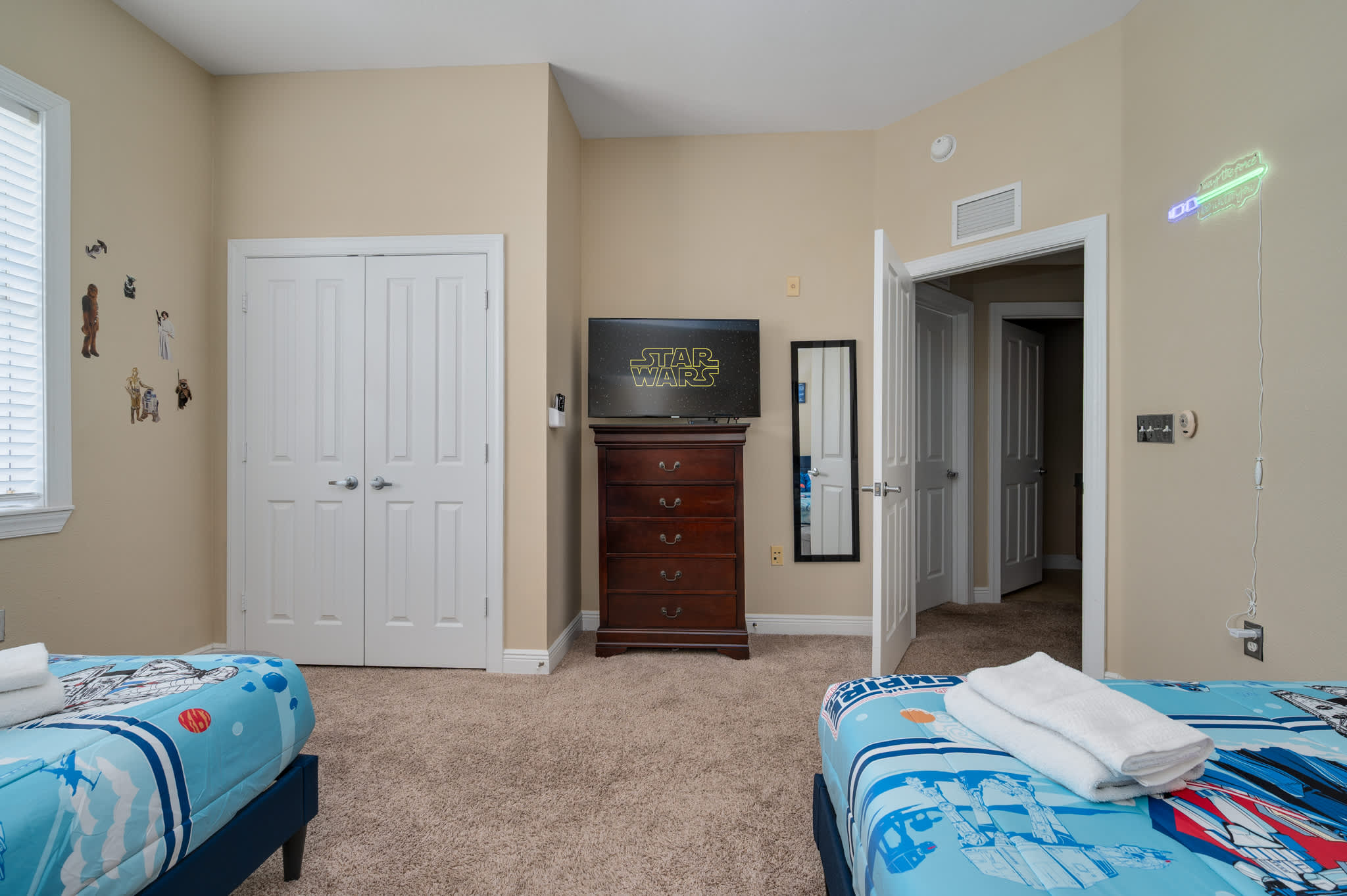 Embark on a galactic adventure in this Star Wars-themed bedroom, featuring two comfortable beds, a TV for entertainment, and a spacious closet for all your gear!