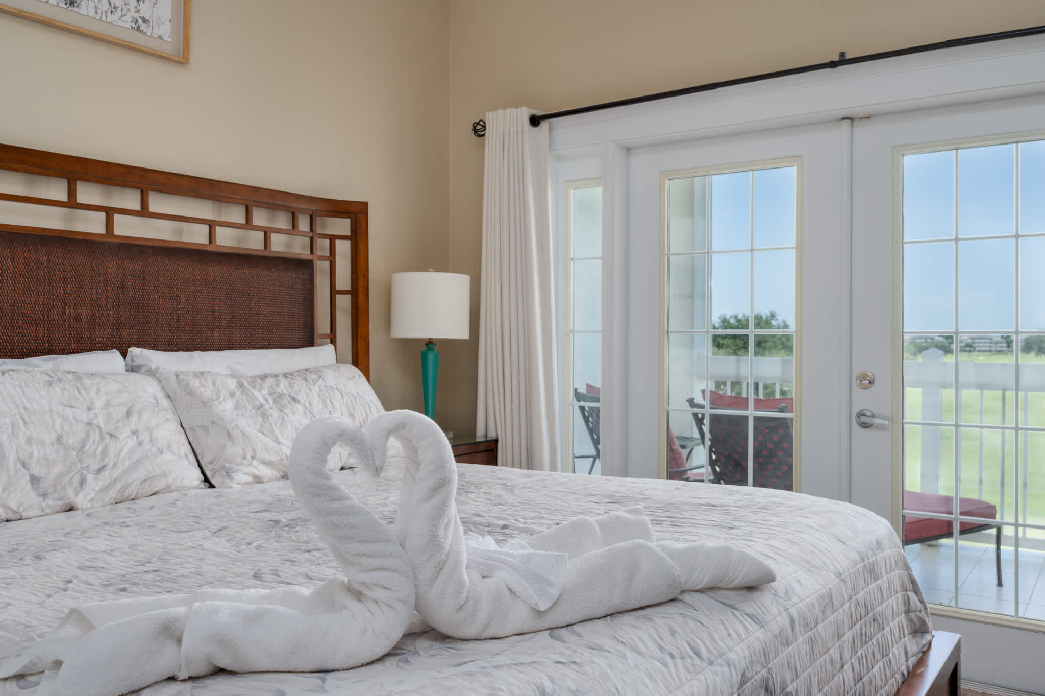 Relax in luxurious comfort in this master bedroom, featuring a plush bed and private balcony with scenic views.